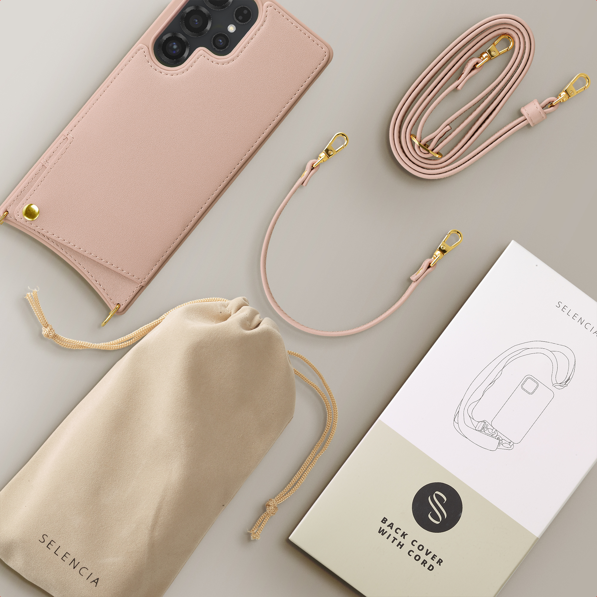 A pink phone back with cord, pouch, and packaging on a gray background.