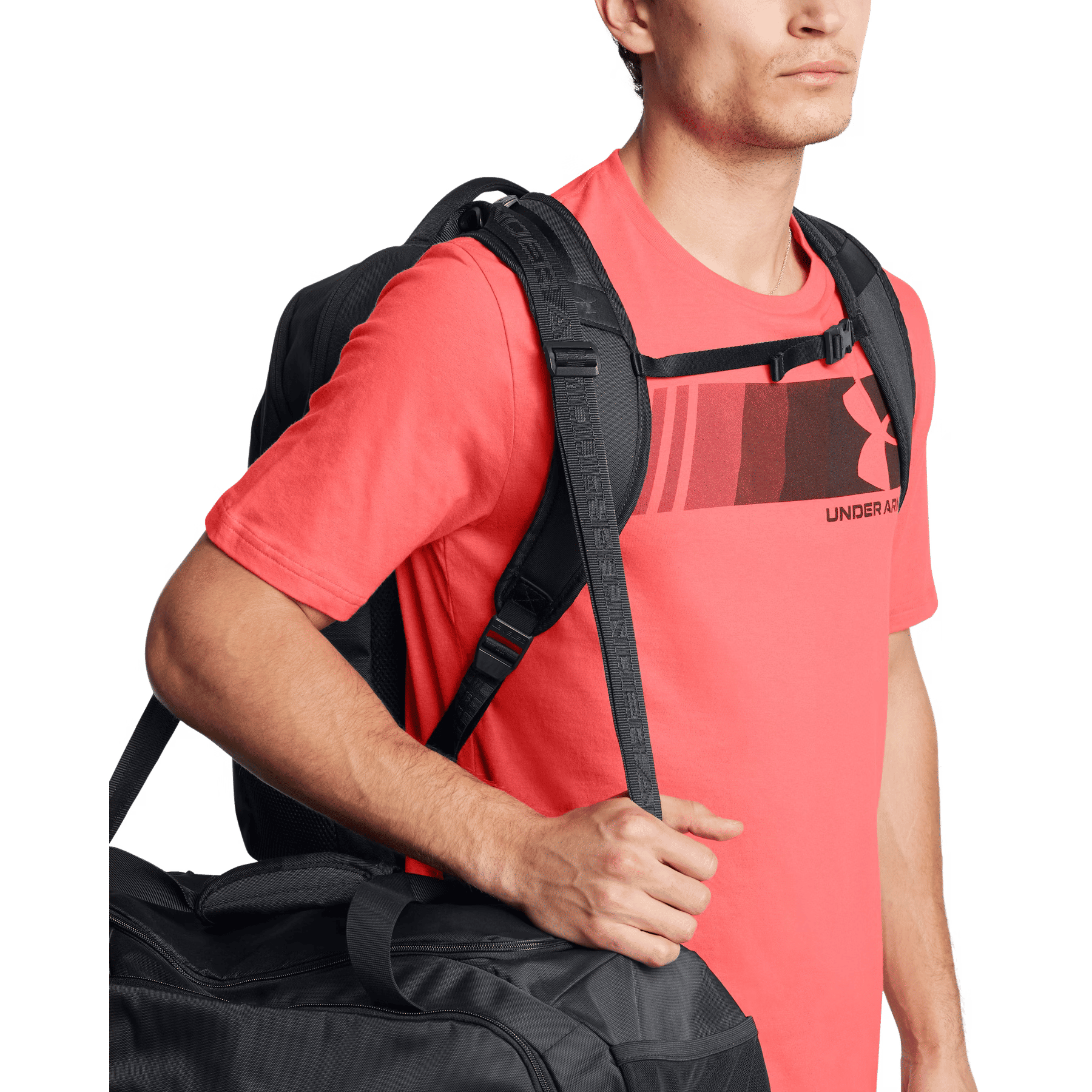 Mann in Korall-T-Shirt mit Rucksack und Sporttasche.