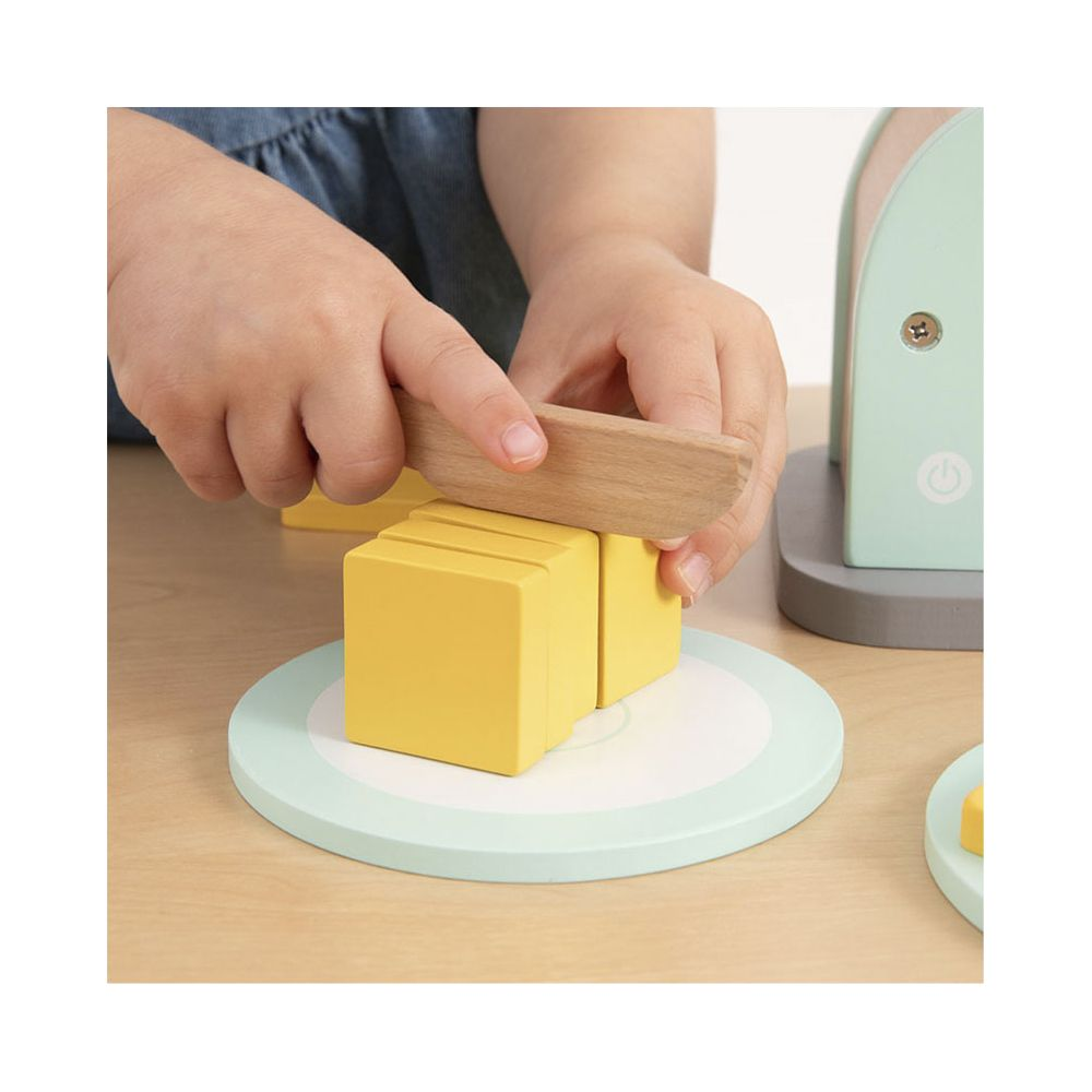 Kinderhände schneiden gelbe Holzklötze mit einem Holzmesser auf einem hellblauen Teller.