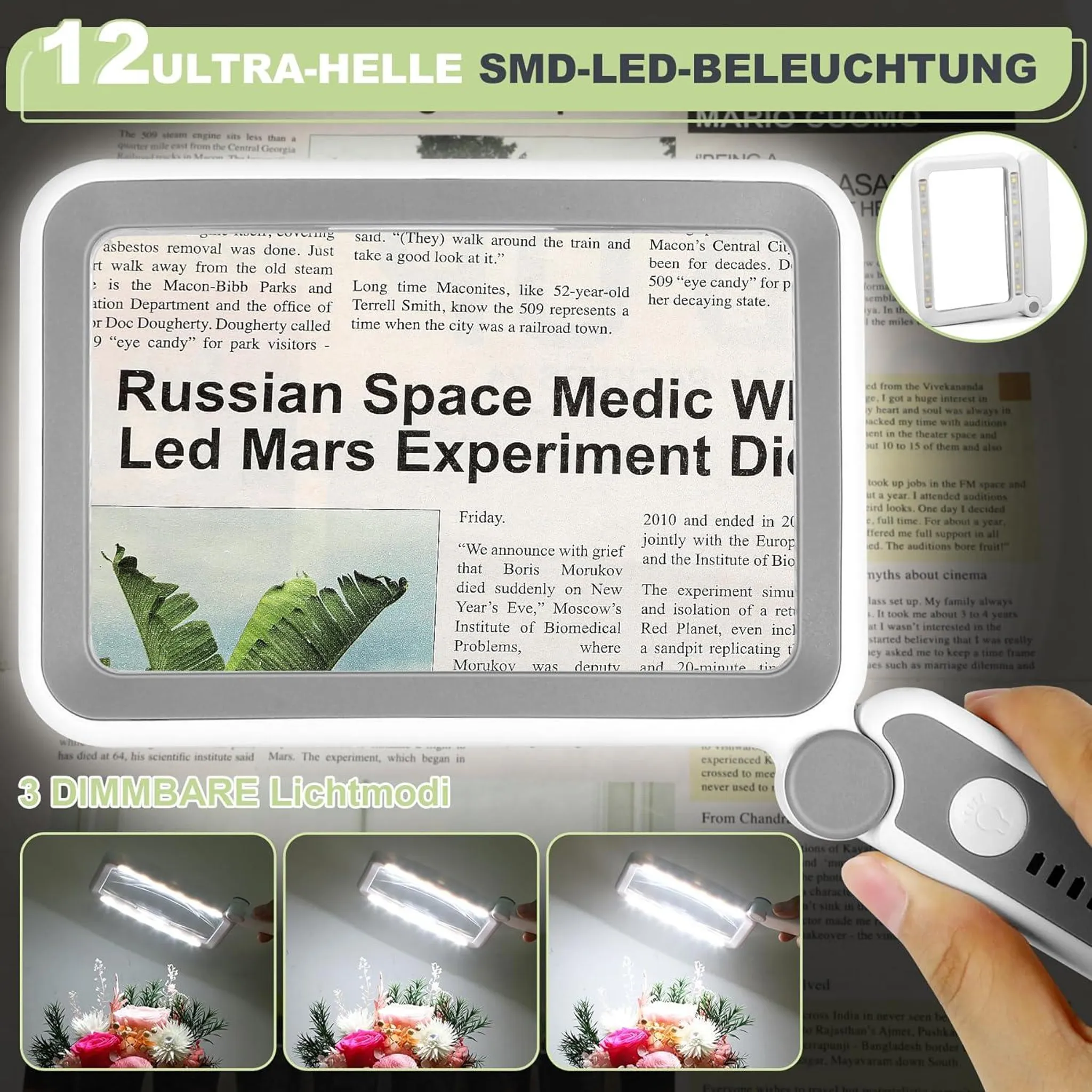 Lupe mit LED-Beleuchtung über Zeitung. "Russian Space Medic" Schlagzeile.