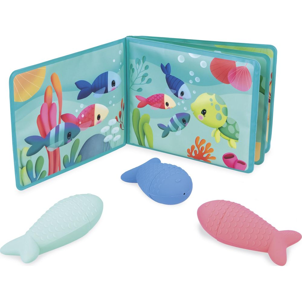 Offenes Buch mit Meeresbewohnern und drei Fischspielzeugen davor.