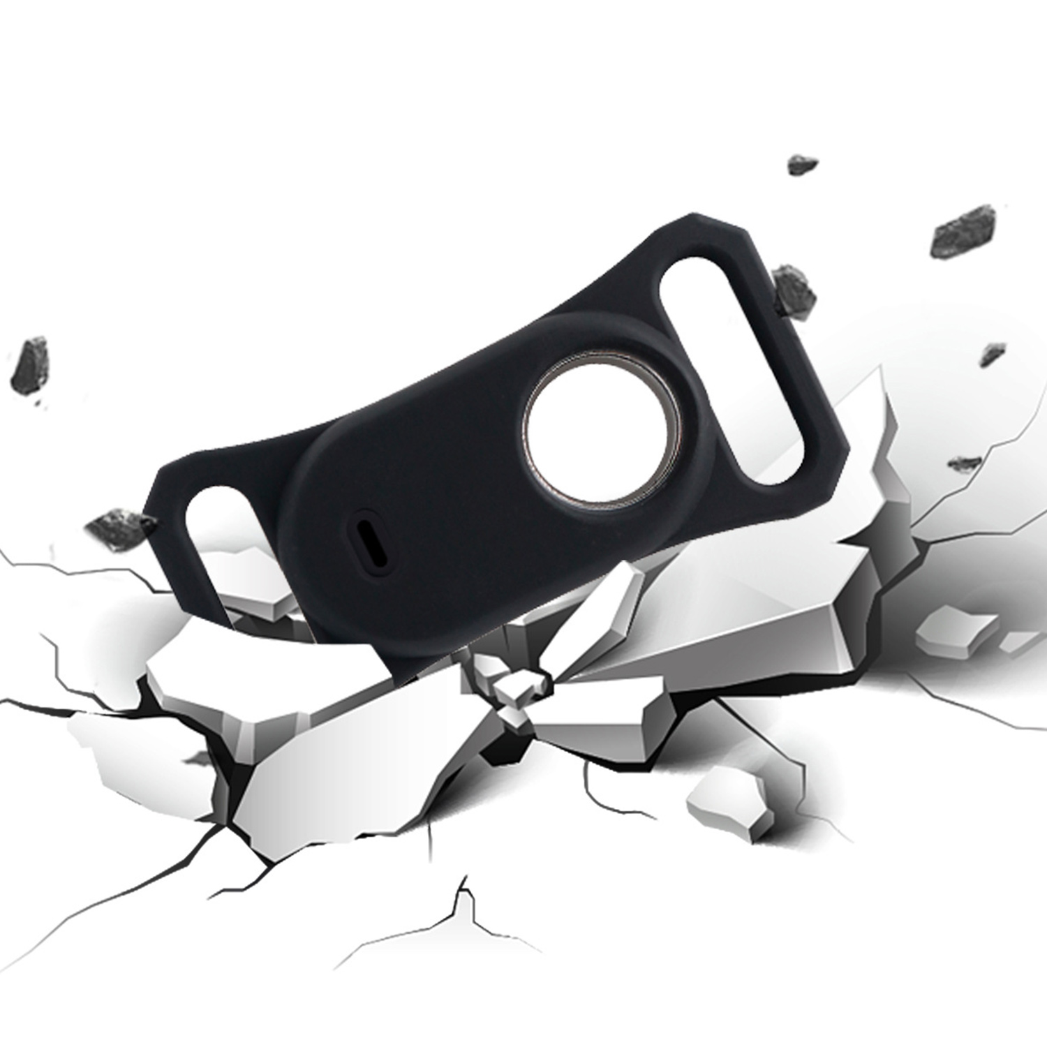 Ein schwarzer Schutz für ein Apple AirTag bricht durch eine weiße Oberfläche.