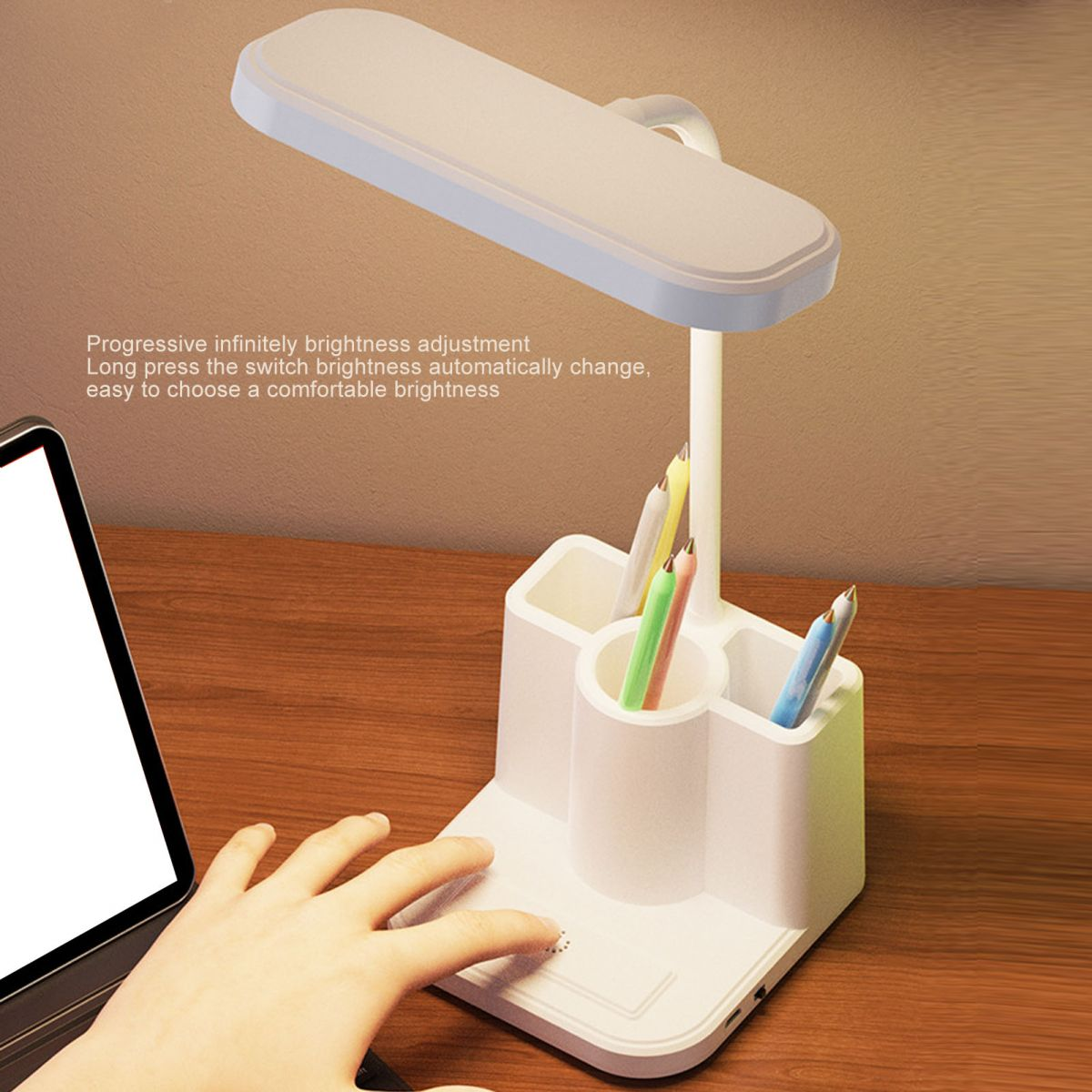 Ein weißer Schreibtisch Organizer mit Lampe, Stiften und einer Hand.