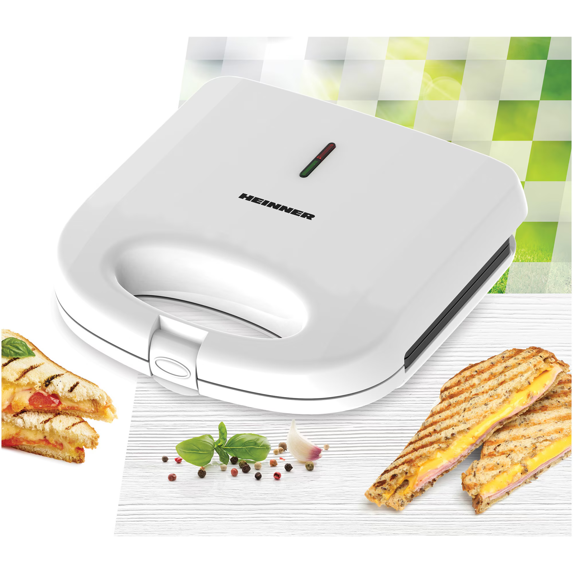 Een witte sandwichmaker met twee afgewerkte sandwiches ernaast.