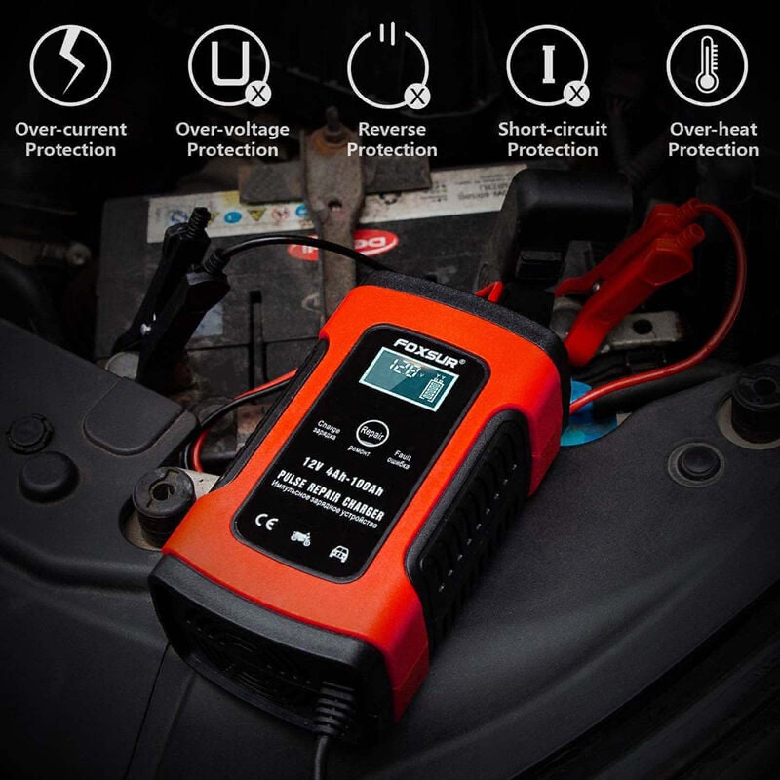 Ein oranges Autostarthilfegerät mit Klemmen an einer Autobatterie.