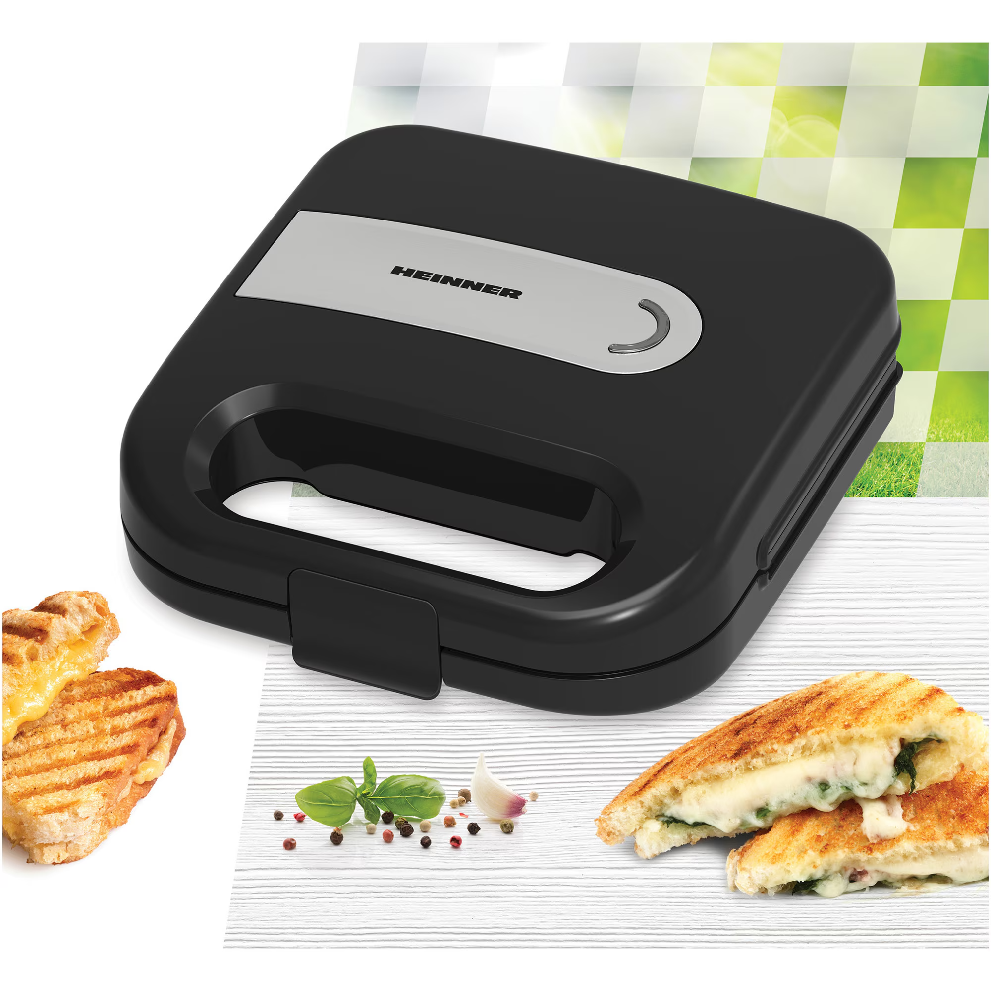 Black sandwich maker with grilled sandwiches and herbs.