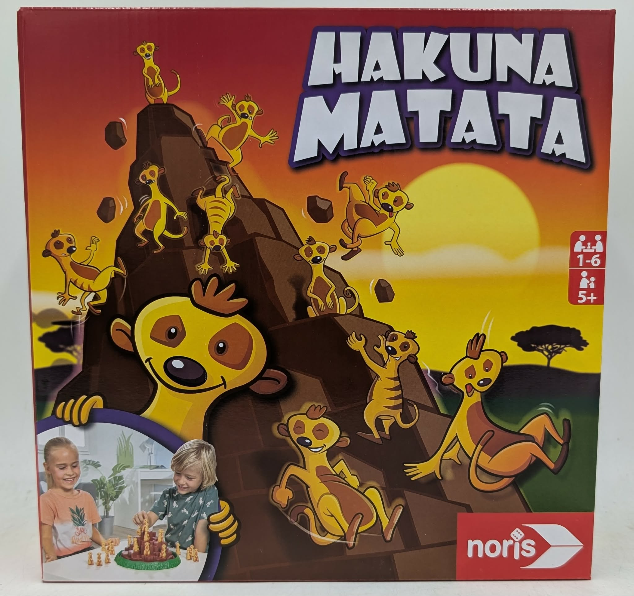 Hakuna Matata Brettspielbox mit Erdmännchen-Motiv und spielenden Kindern.