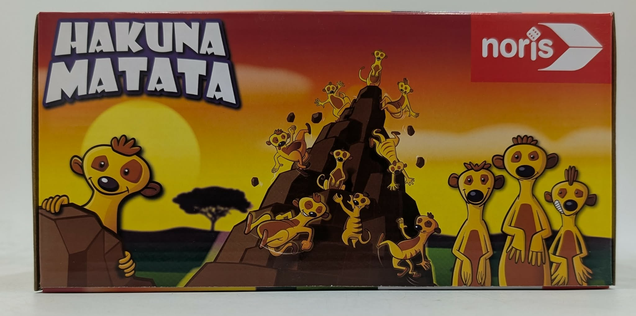 Hakuna Matata-Schriftzug über Meerkatzen, die auf und um einen Felsen klettern.