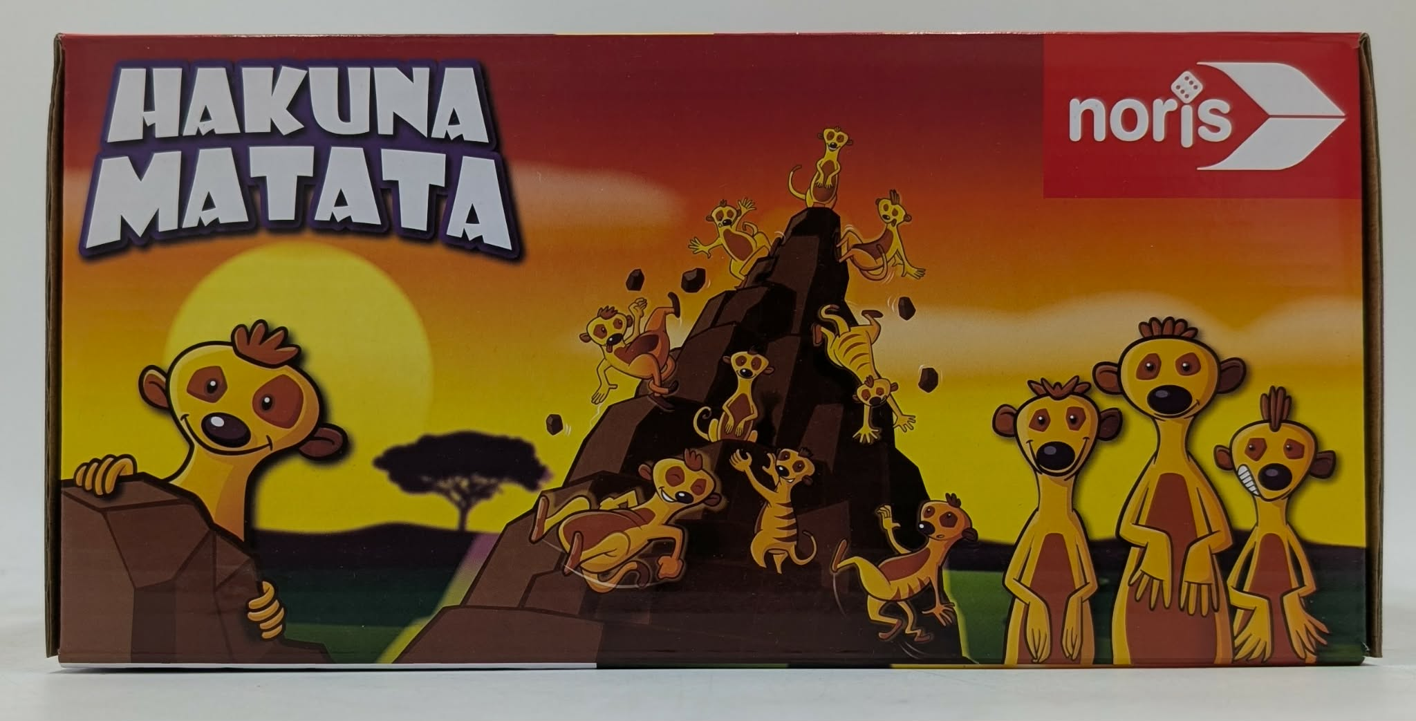 Hakuna Matata Box-Art zeigt Erdmännchen auf einem felsigen Hügel vor Sonnenuntergang.
