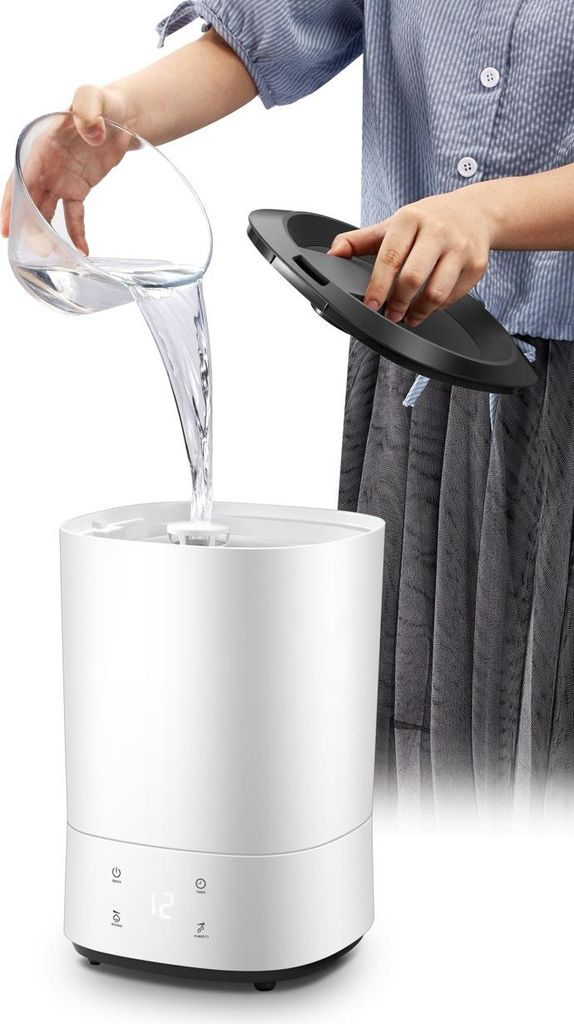 Wasser wird aus einem Glas in einen weißen Luftbefeuchter gegossen.