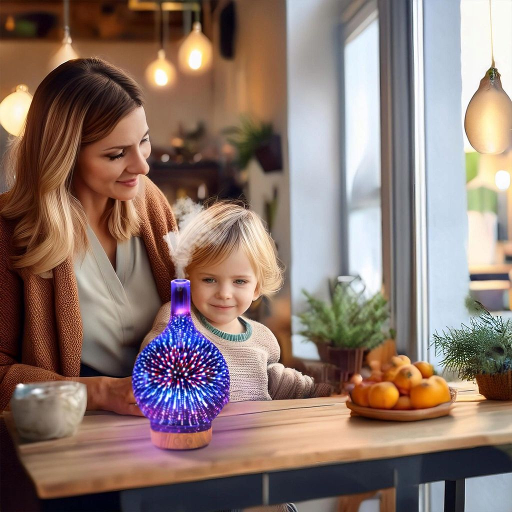 Frau und Kind sitzen an einem Tisch mit einem beleuchteten Diffusor und Früchten.