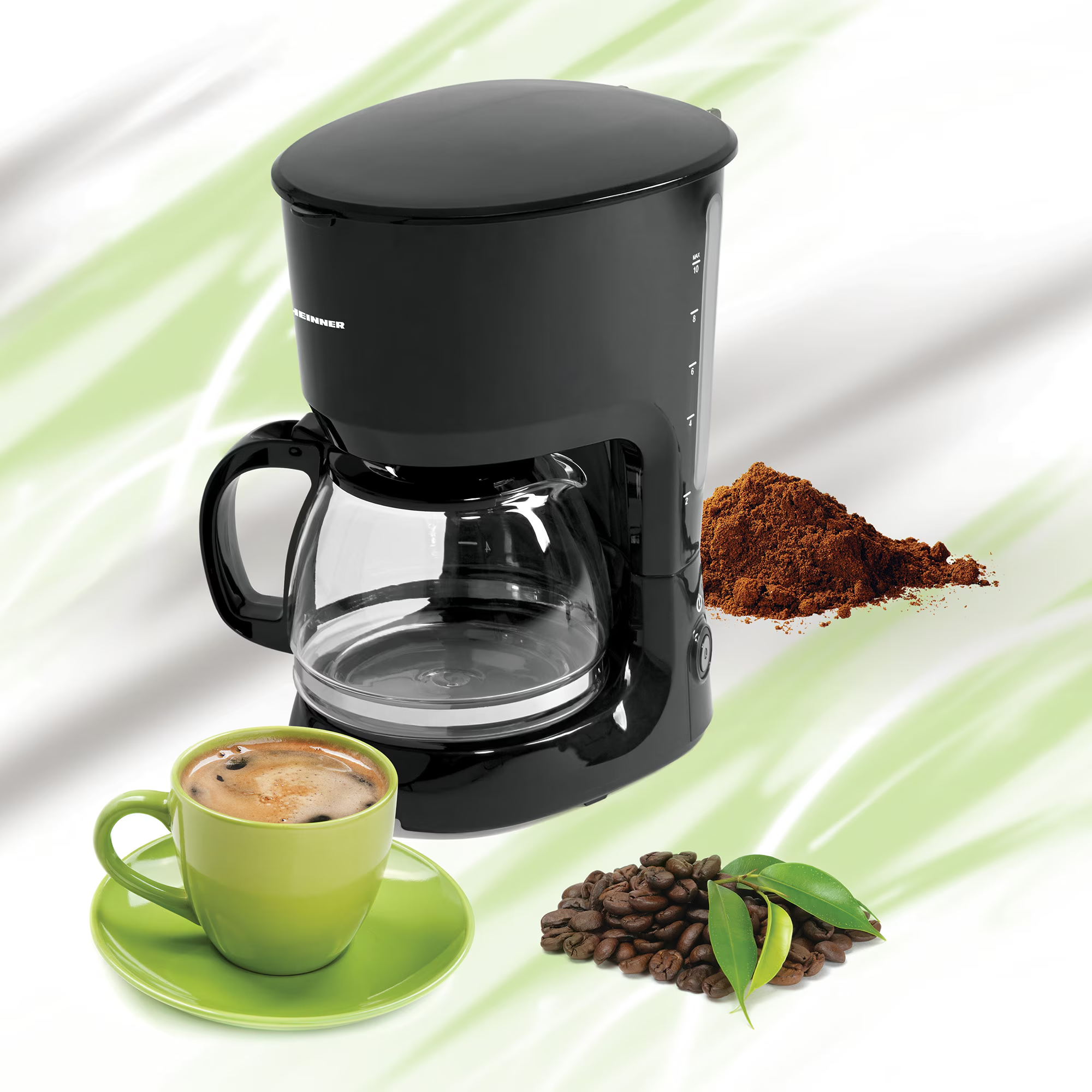 Cafetière noire avec verseuse en verre, tasse à café, grains de café et café moulu.
