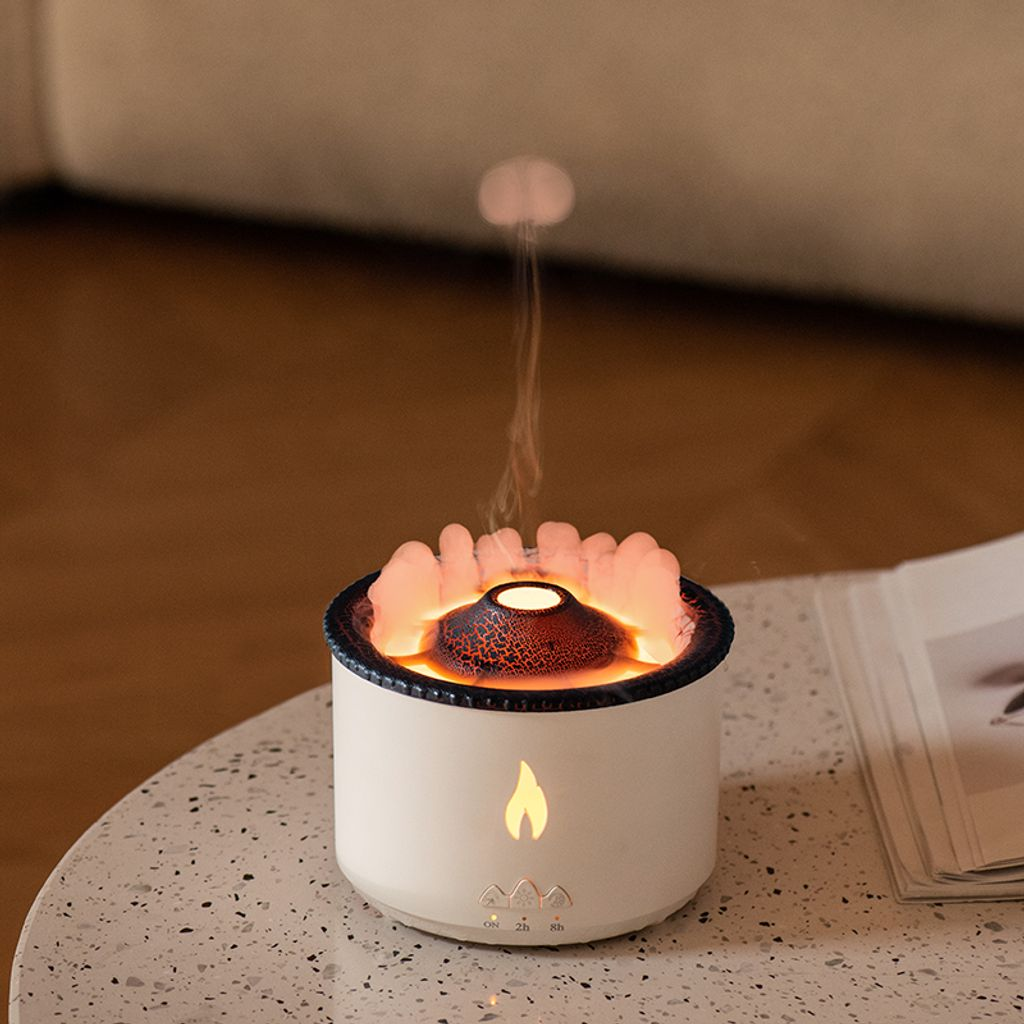 Ein weißer Diffusor mit einem vulkanähnlichen Ausguss, der Dampf ausstößt. Orange Lichter umranden die Oberseite.