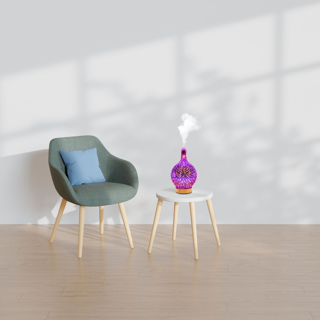 Ein violetter Diffusor mit Sternenmuster gibt Dampf ab, neben einem Sessel mit Kissen.
