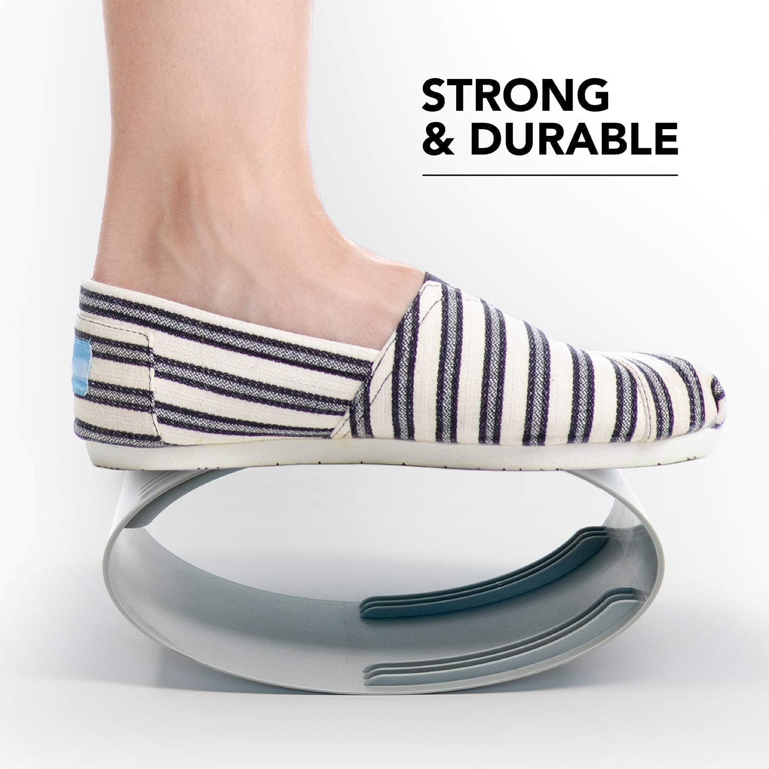 Ein gestreifter Schuh steht auf einem grauen, geschwungenen Objekt.