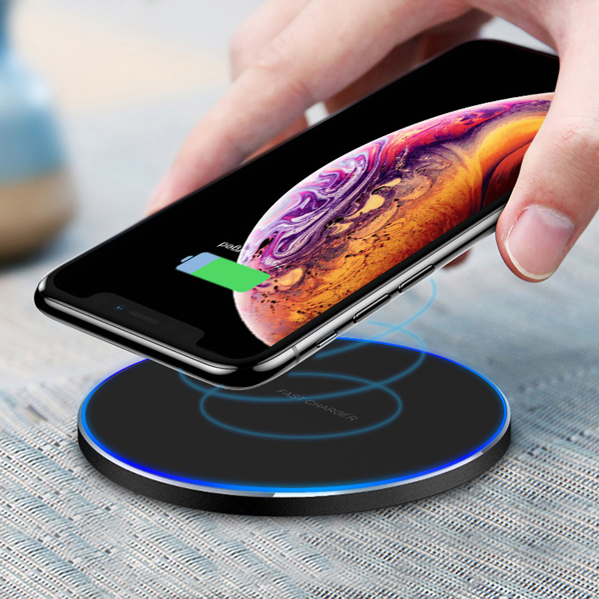 Ein Smartphone wird auf ein schwarzes kabelloses Ladegerät mit blauer LED gelegt.