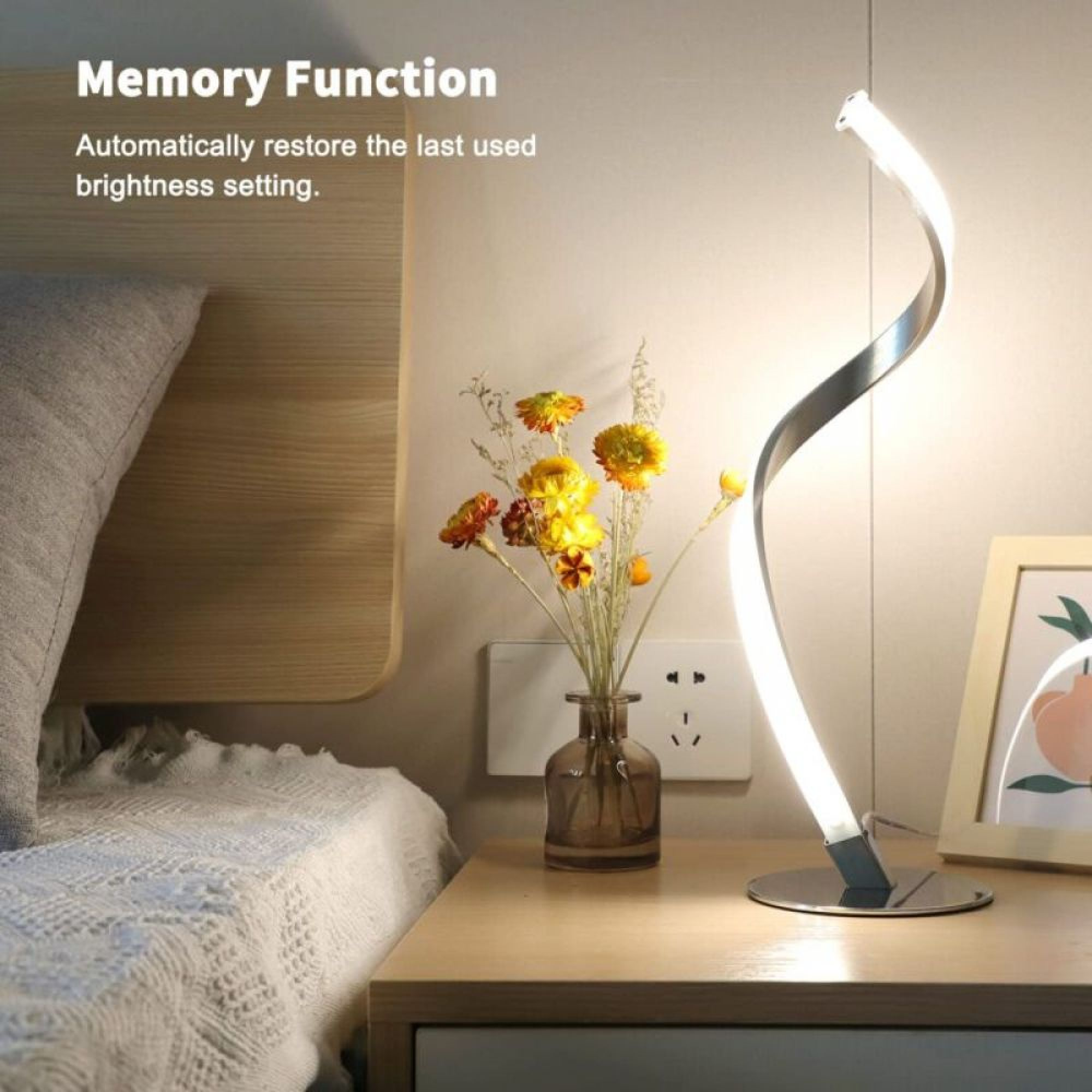 Moderner Nachttisch mit Lampe, Blumen und gerahmter Kunst. Bett mit weißer Decke.