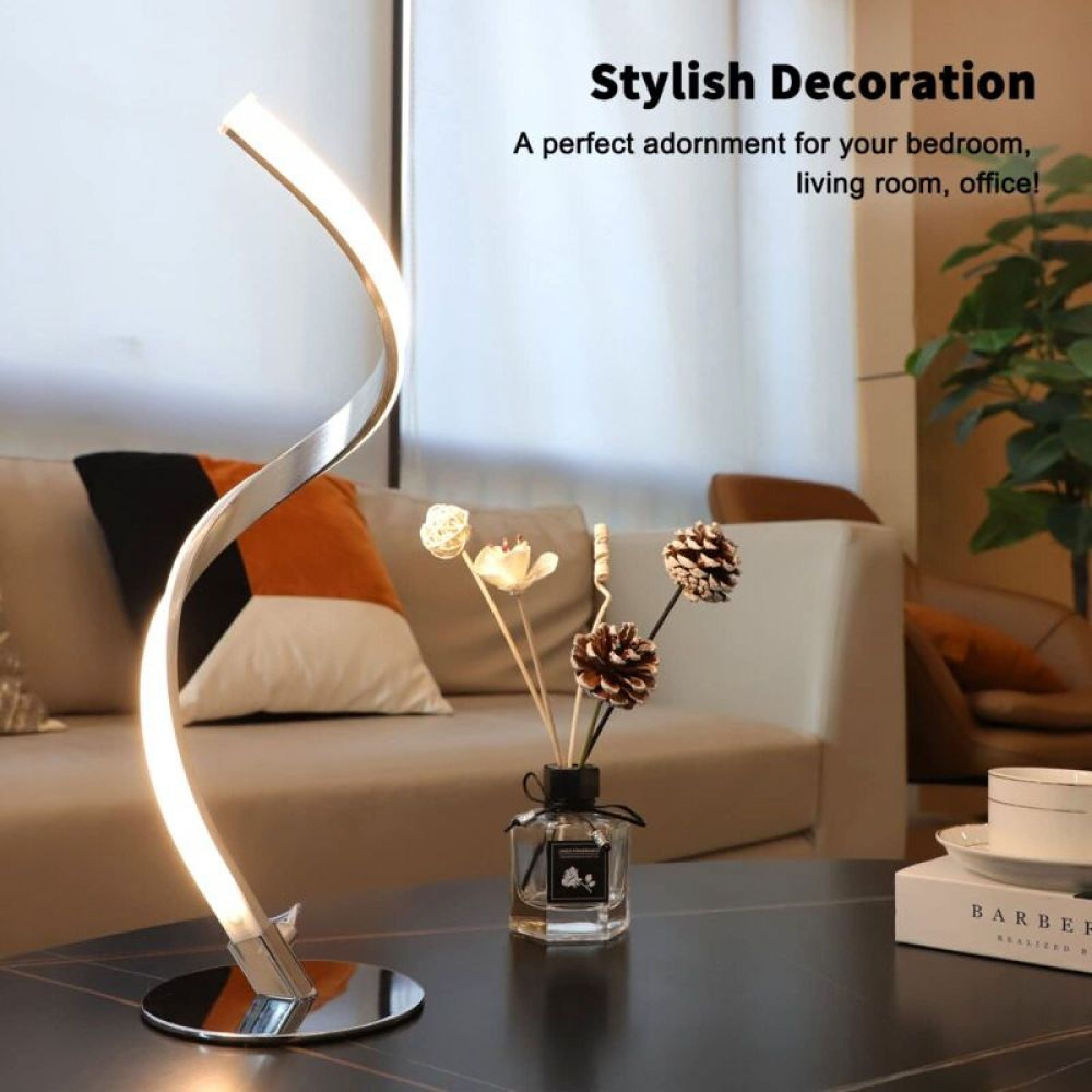 Eine moderne Lampe steht auf einem Tisch vor einem Sofa mit Kissen.