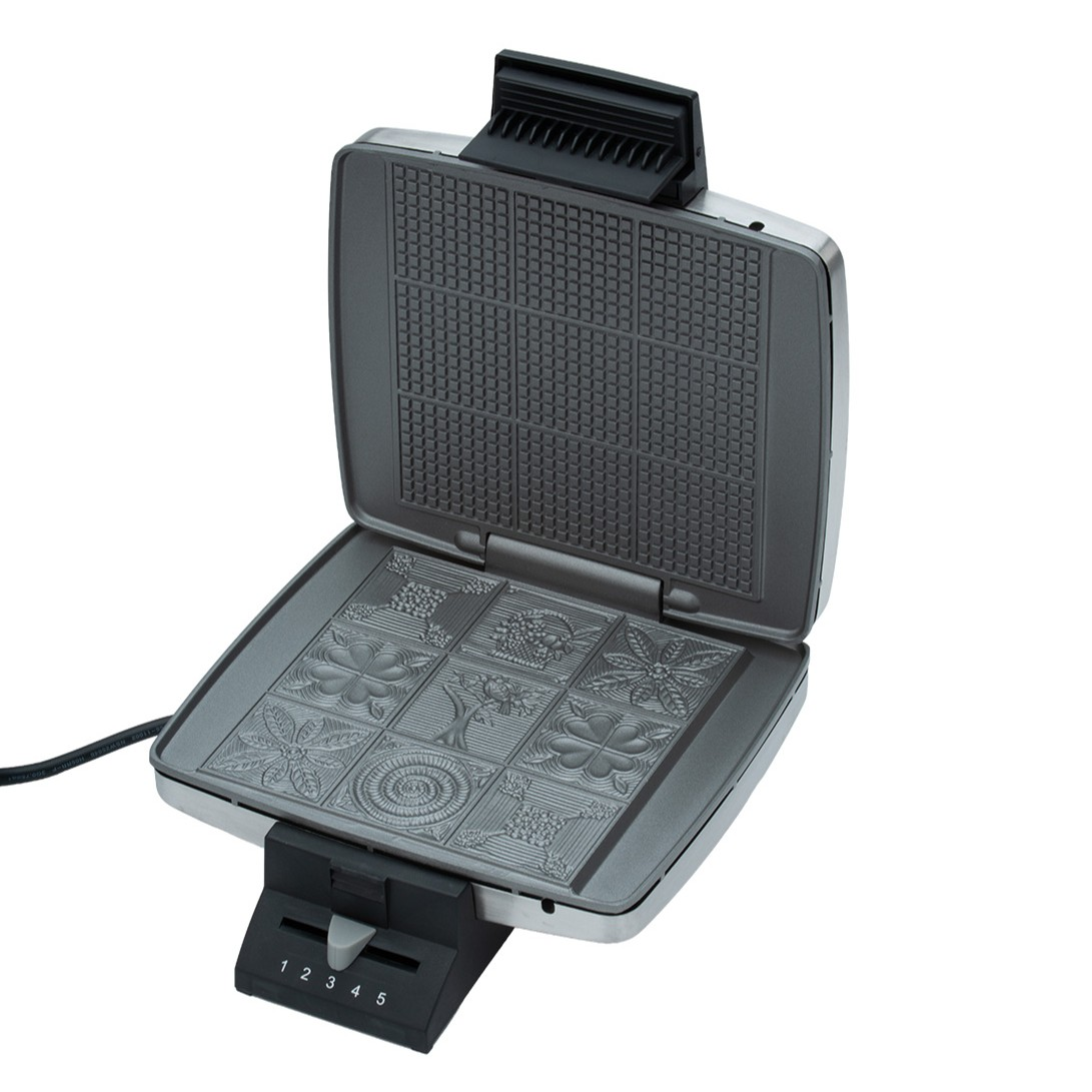 Ein offener Waffelautomat mit eingravierten Mustern auf der unteren Platte.