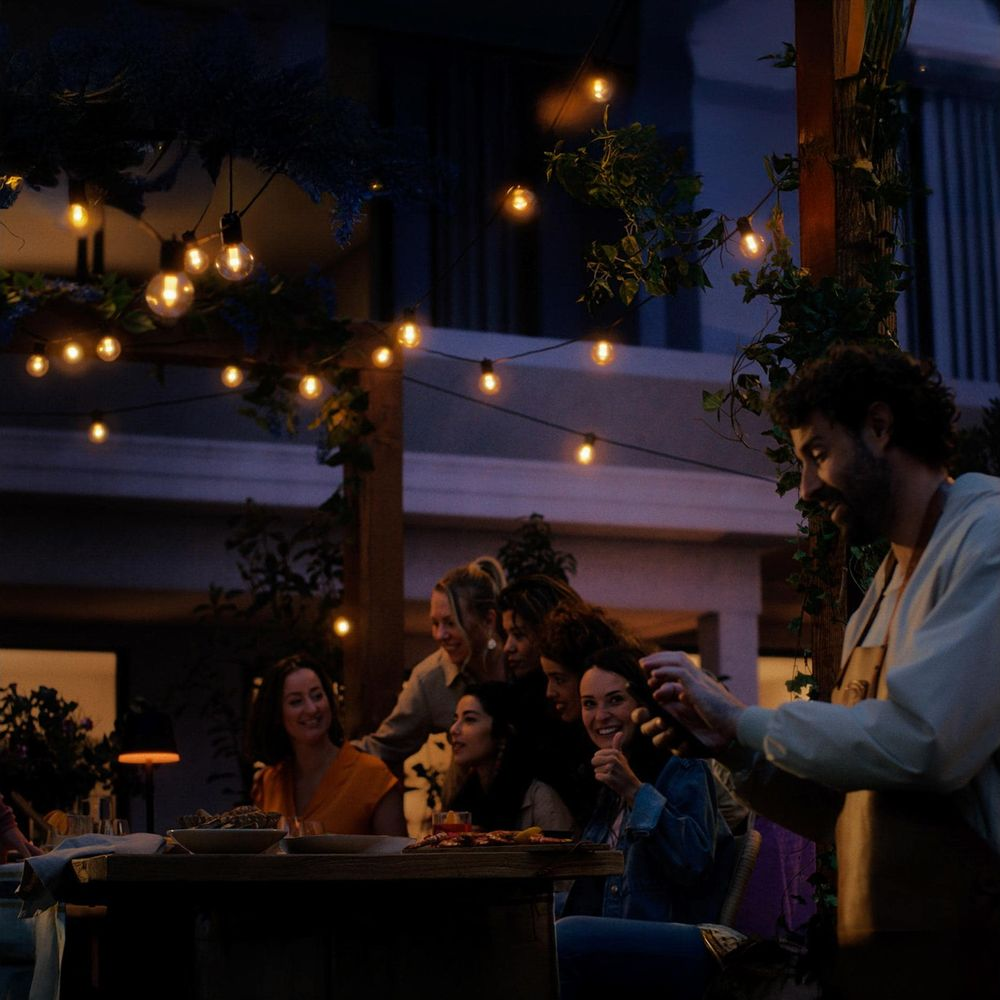 Gruppo di amici che festeggiano all'aperto di notte con luci.