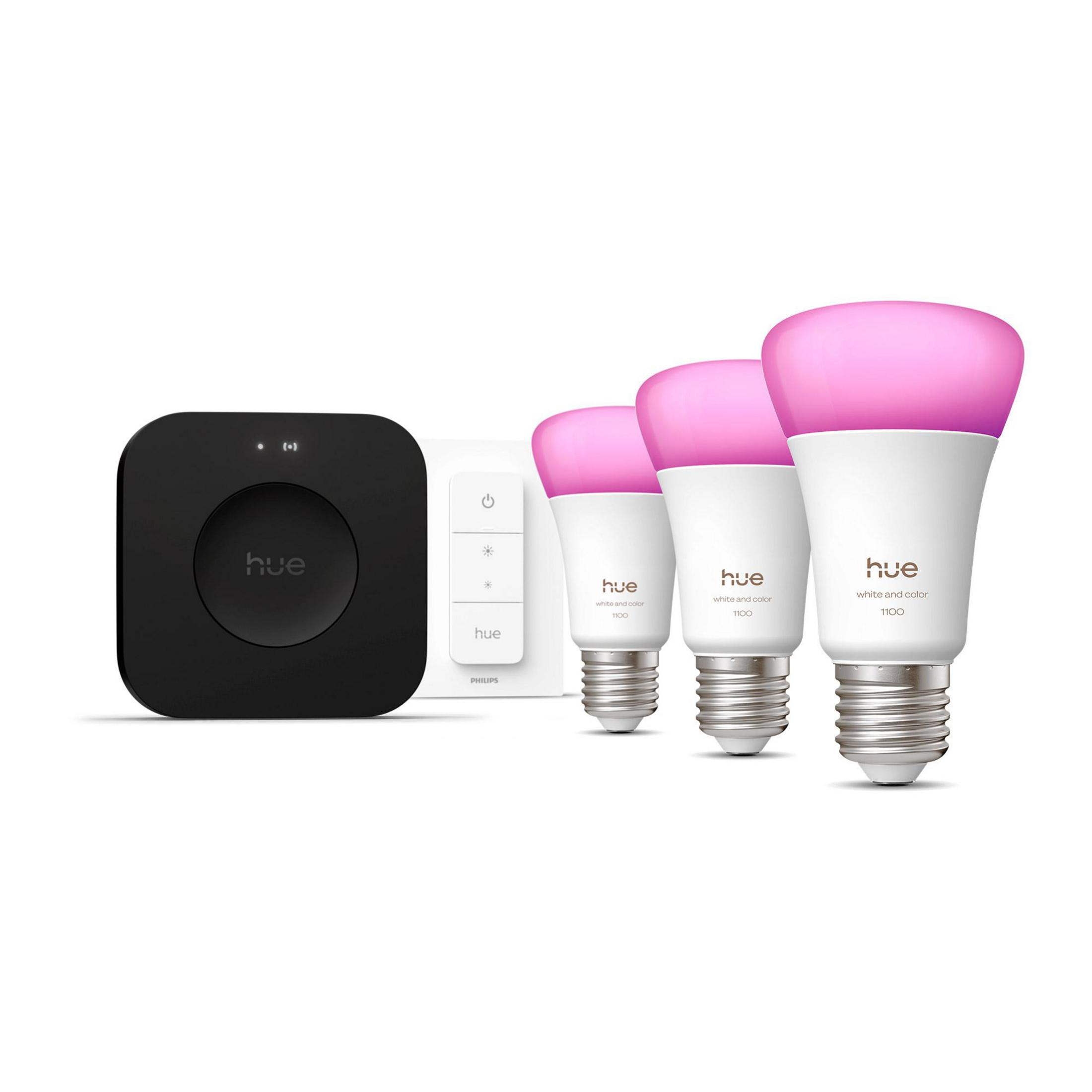 Een zwarte Hue hub, een witte dimmer en drie roze Hue lampen.
