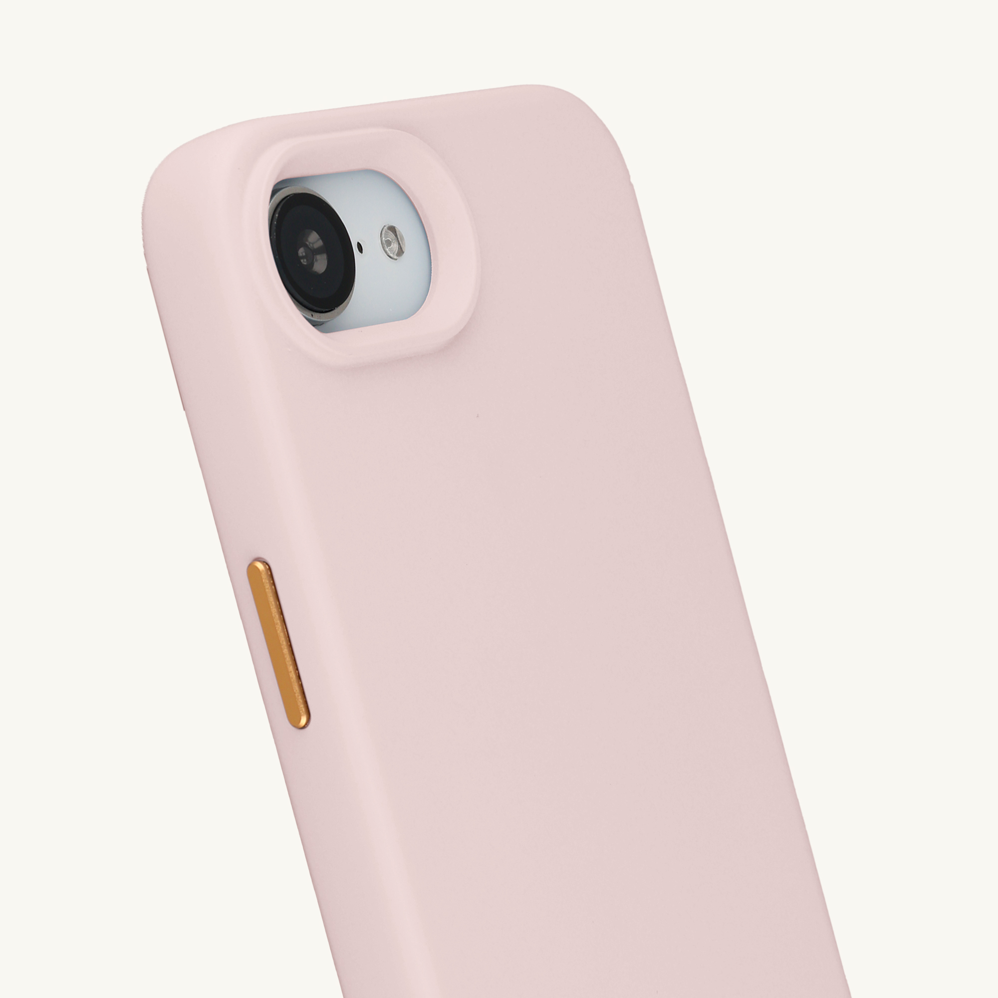 Une coque de téléphone rose avec zone caméra et bouton doré.