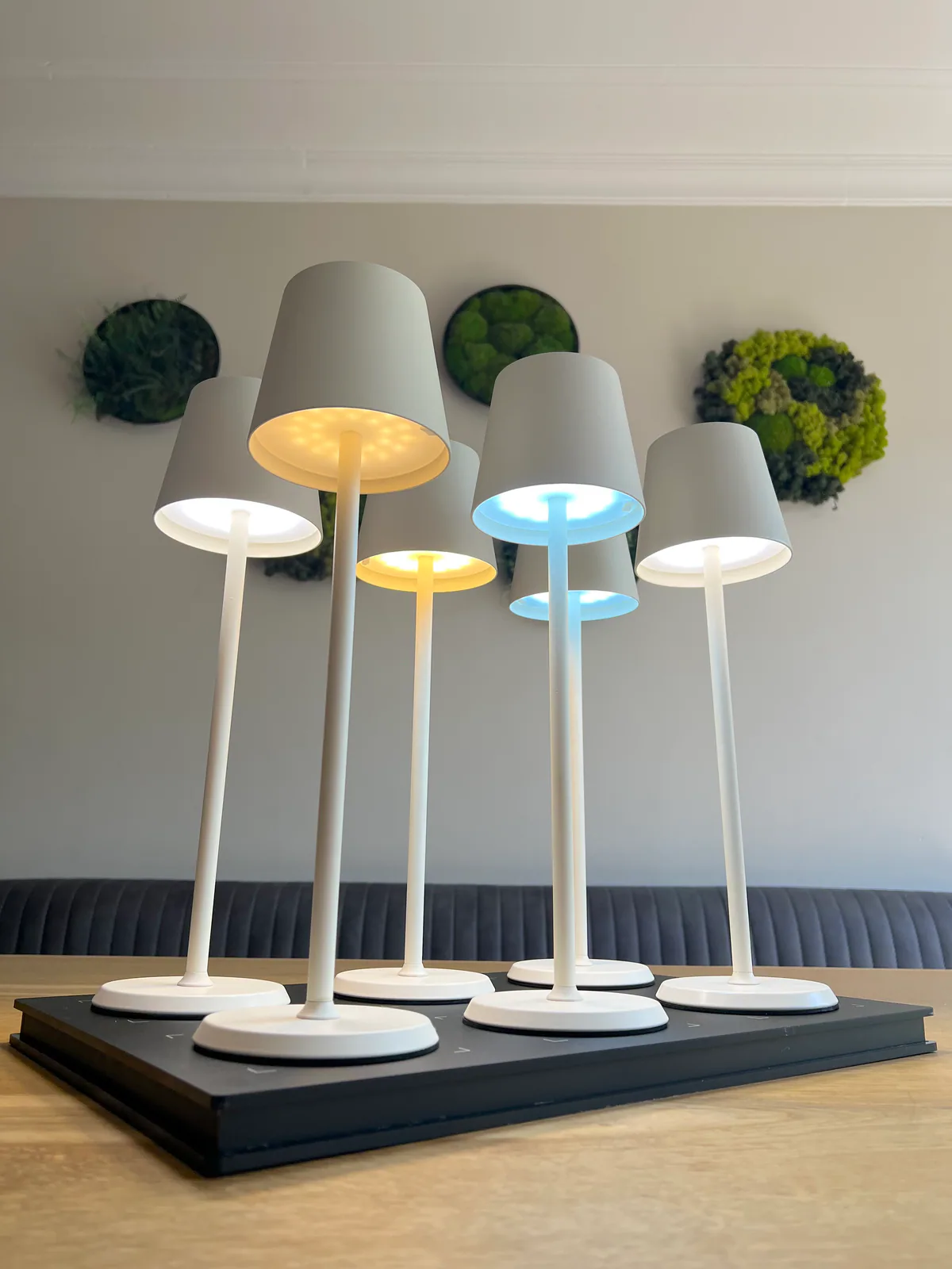Fünf weiße Lampen mit verschiedenen Lichtfarben auf einem Tisch.