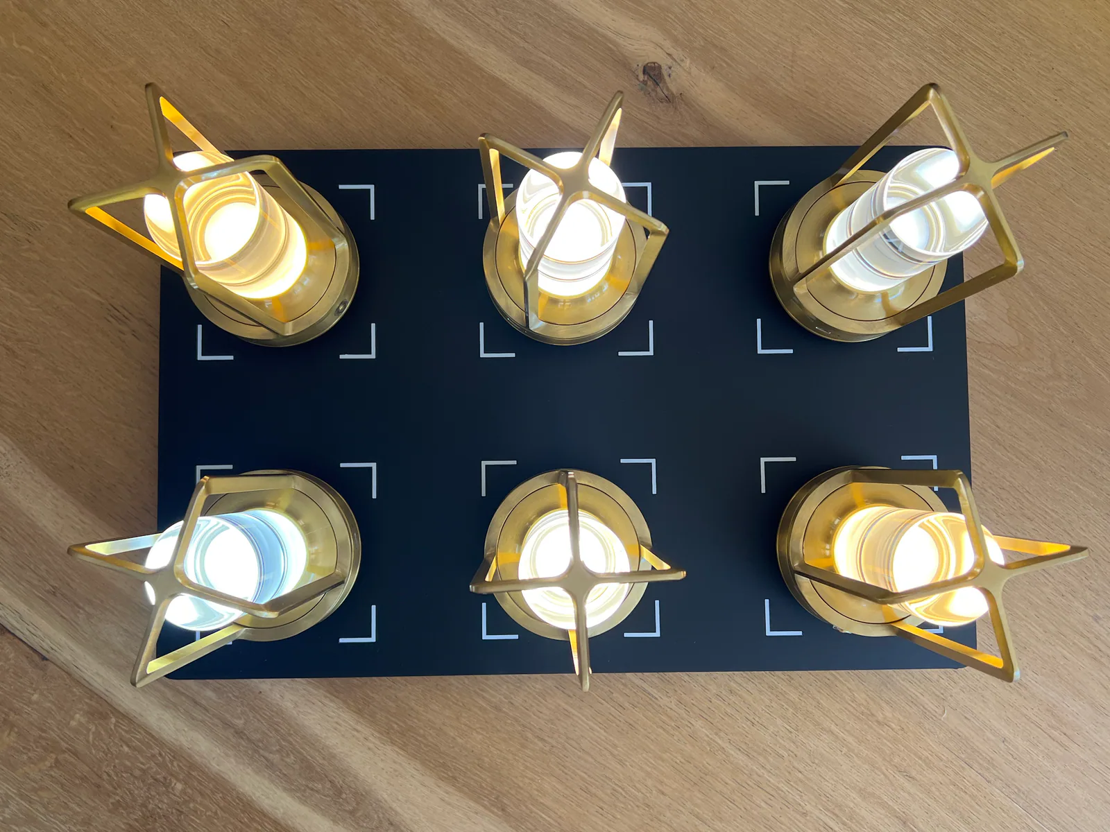 Sechs goldene Lampen auf schwarzem Hintergrund auf Holztisch.