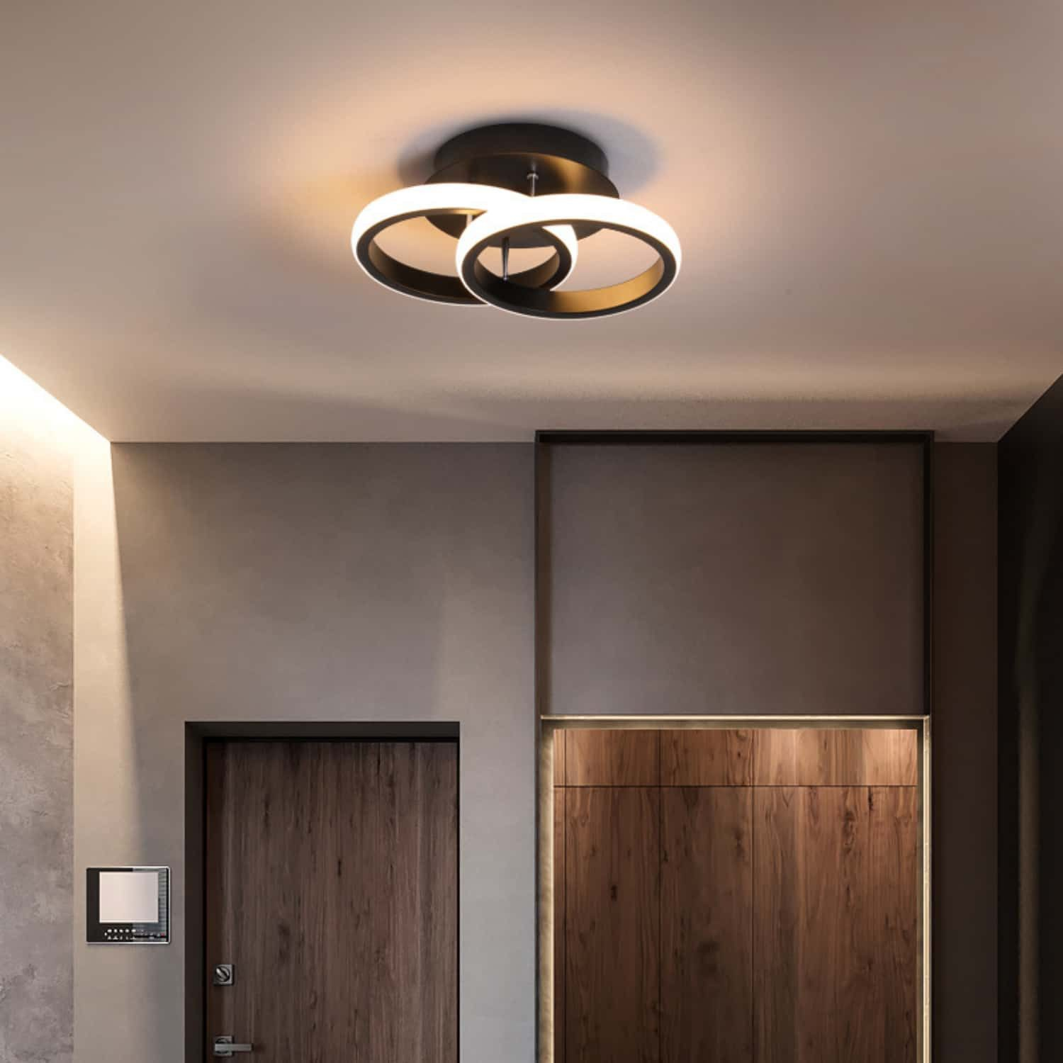 Moderne Deckenleuchte mit zwei Ringen über Holztüren und einer Wandplatte.