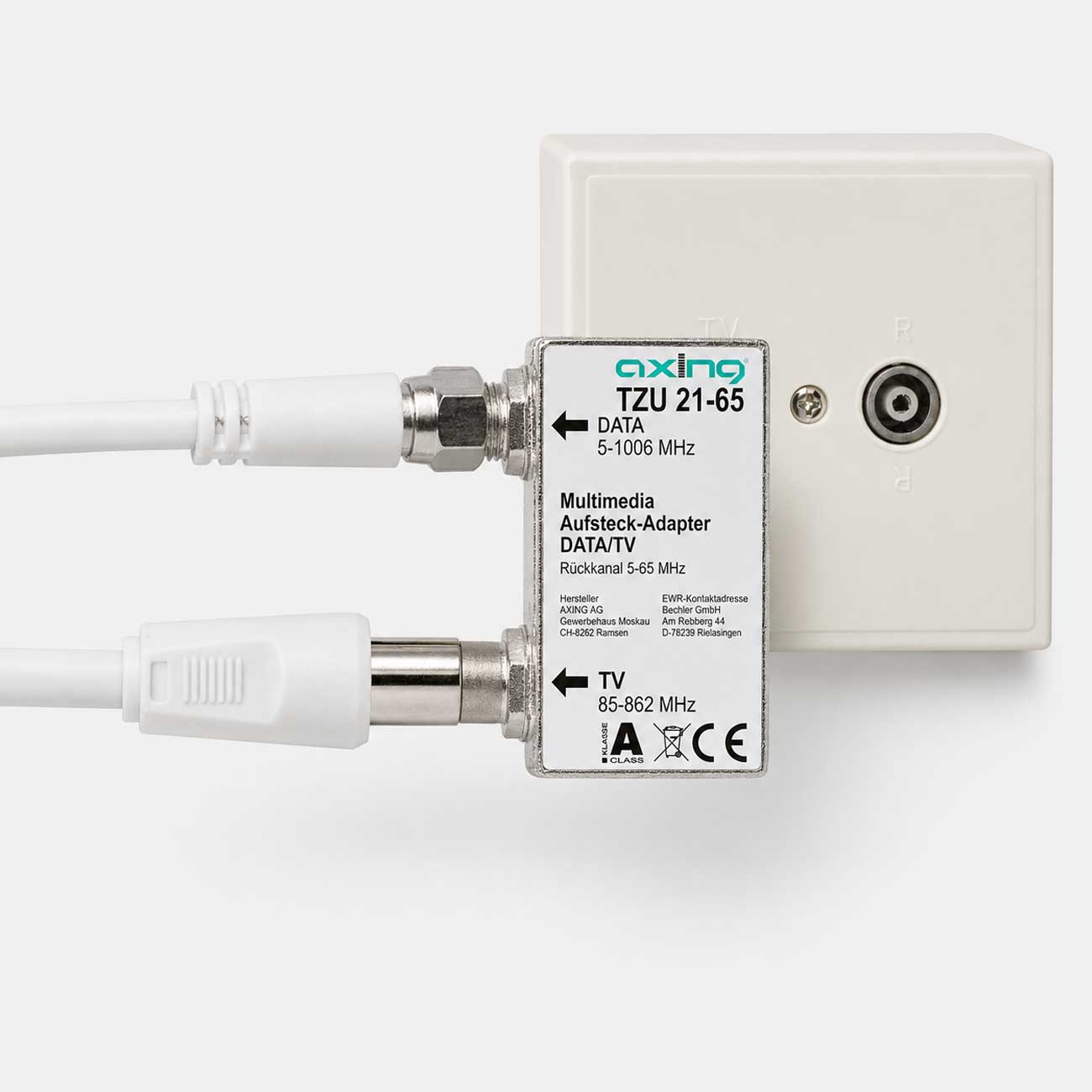Ein Axing Multimedia Adapter TZU 21-65 zwischen zwei Kabeln, angeschlossen an eine Wanddose.