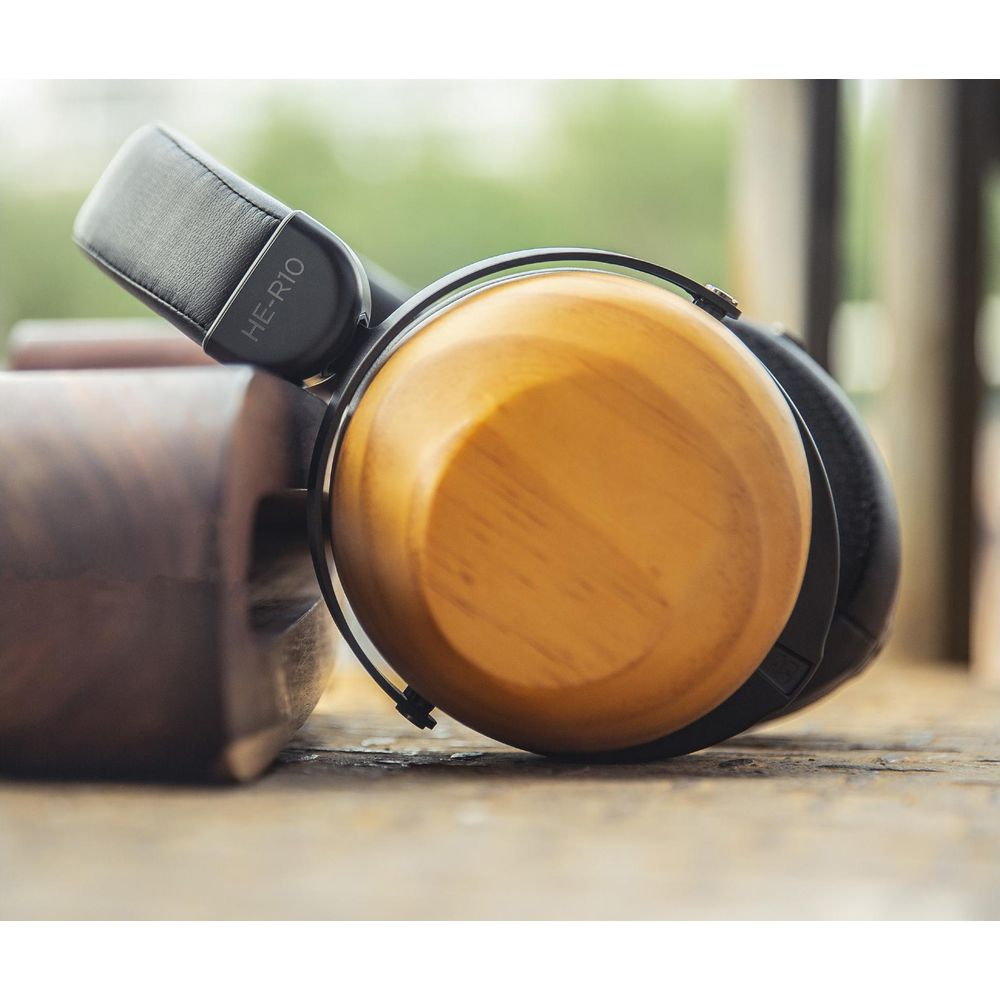 Auriculares de madera con diadema negra sobre mesa de madera.