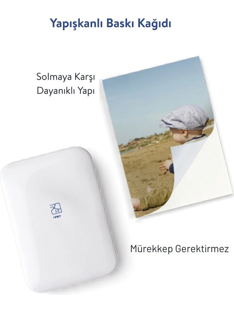 Beyaz bir cihaz, plajdaki bebek fotoğrafının yanında. Mürekkepsiz baskı.