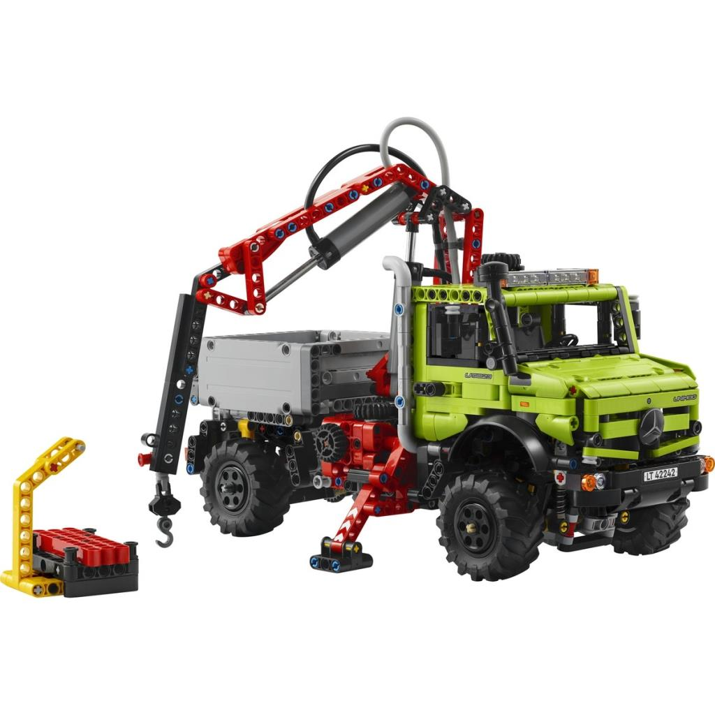 Sarı bir stant ve vinçli yeşil Lego kamyon.