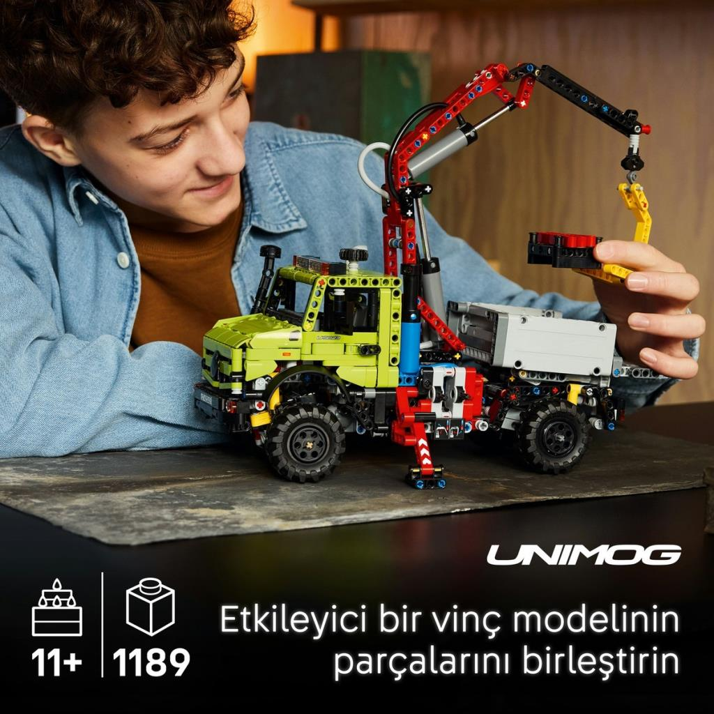 Bir çocuk, vinçli yeşil bir Lego kamyonu inşa ediyor. 11 yaş+, 1189 parça.