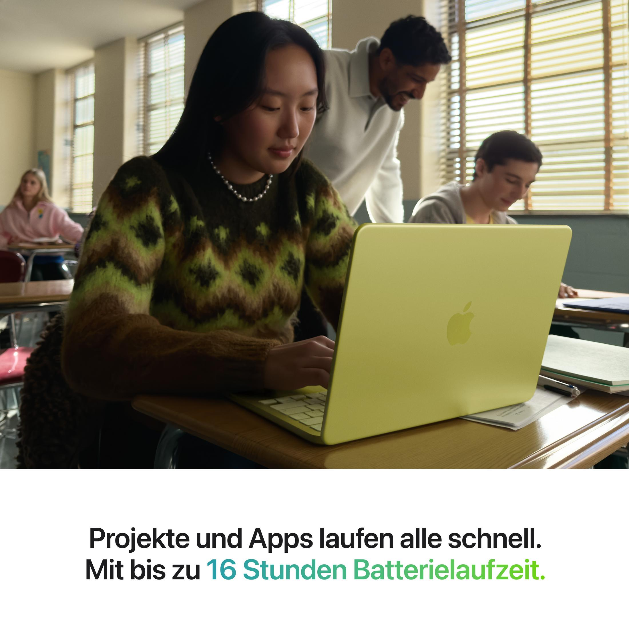 Schüler im Klassenzimmer mit einem hellgelben MacBook Air.