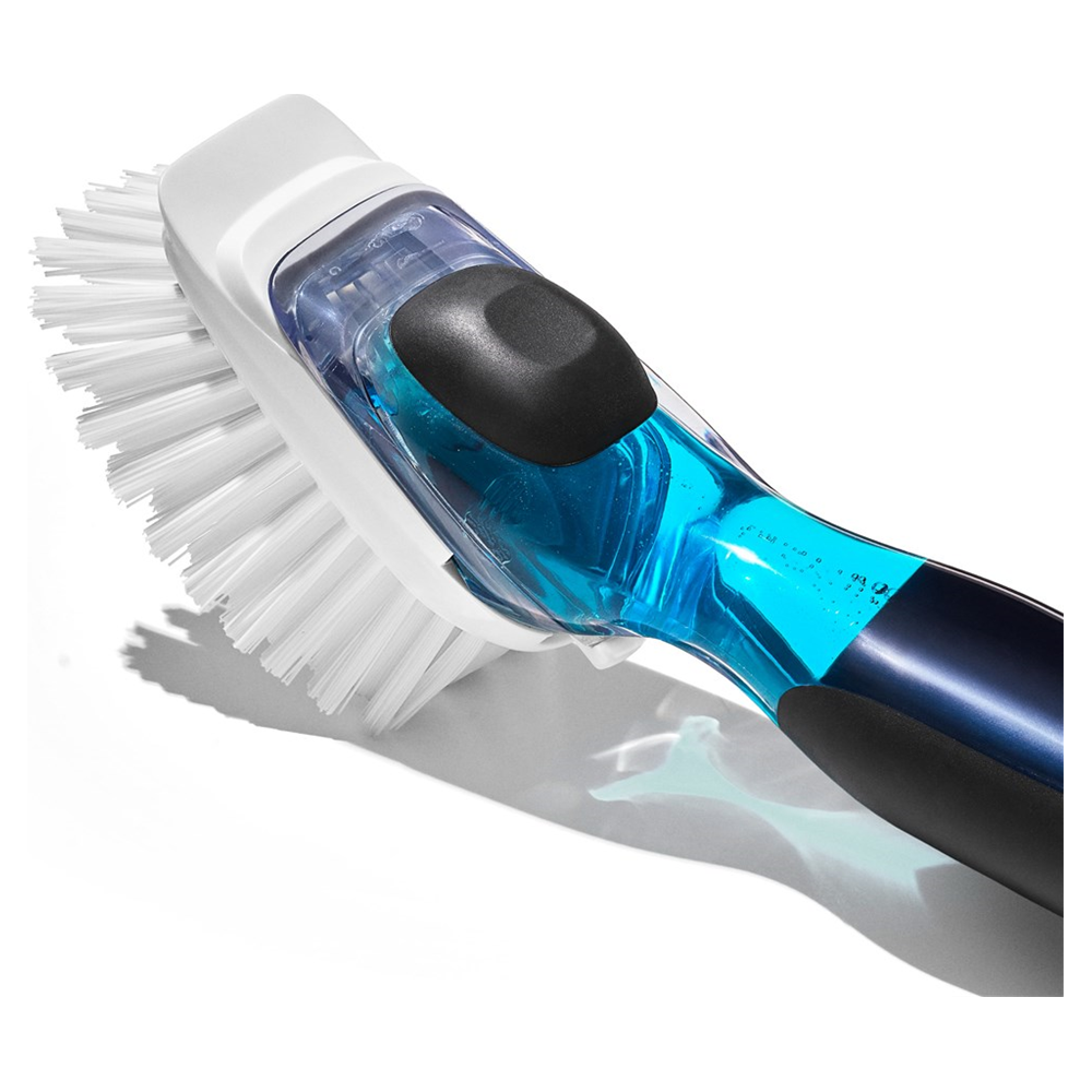 Ein weißer Bürstenkopf mit blauem Griff, gefüllt mit klarer Flüssigkeit.