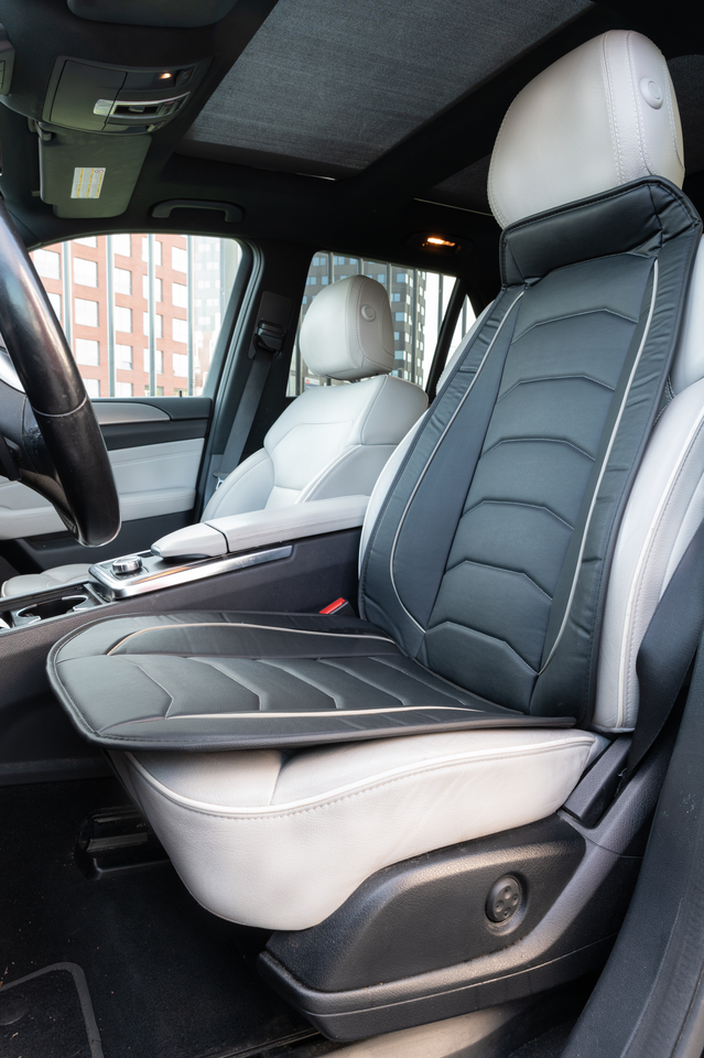 Car interior with leather seats and a seat cover.