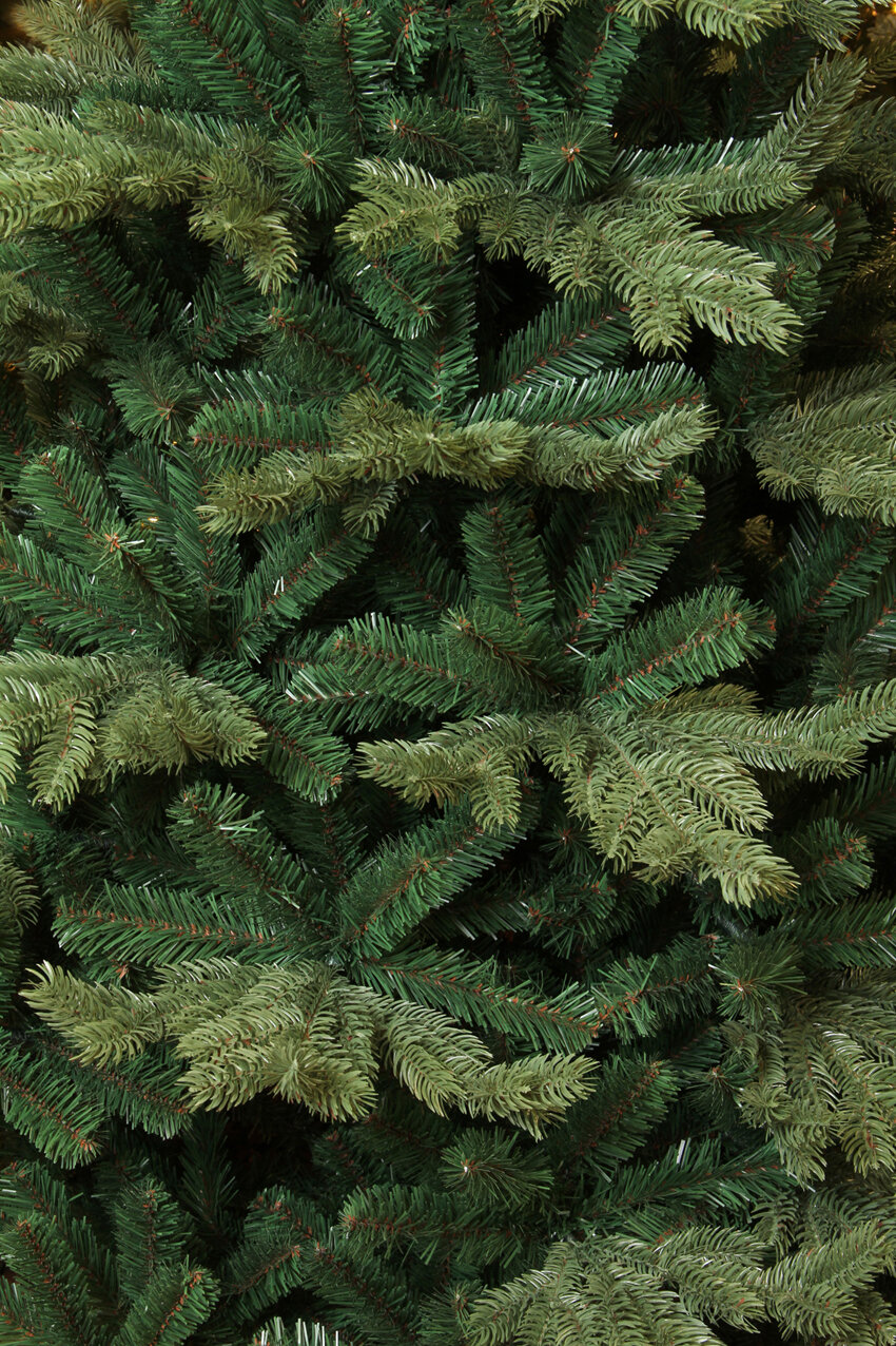 Close-up of dark green and light green pine needles on an artificial Christmas tree.