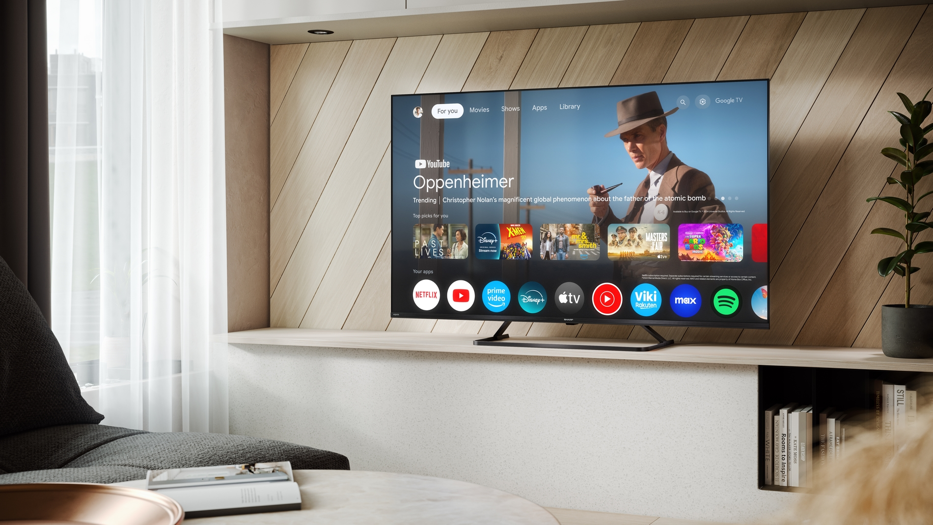 Una TV moderna mostra l'interfaccia di Google TV con film e app.