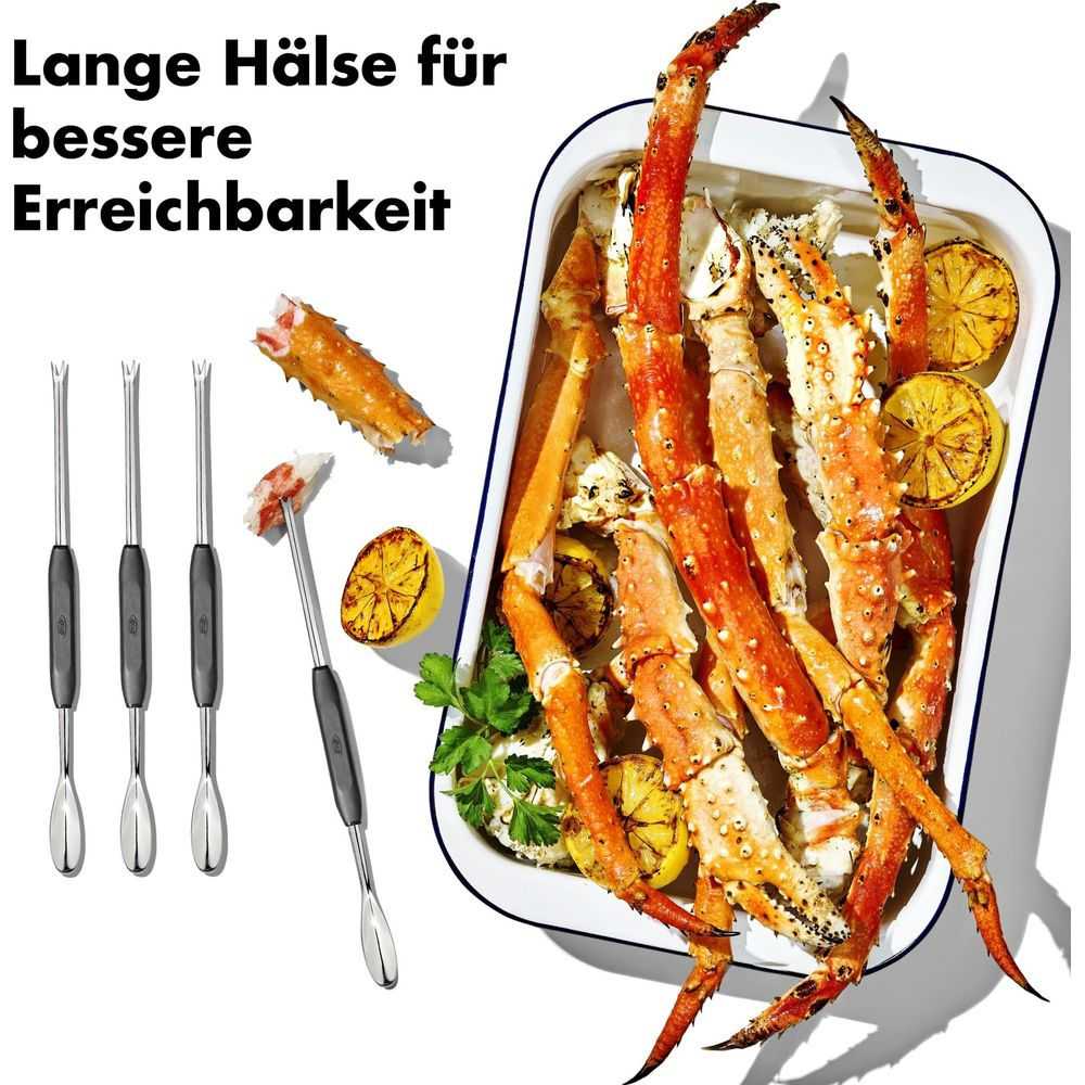 Königskrabbenbeine mit Zitronen und Krabbenbesteck auf weißem Hintergrund.