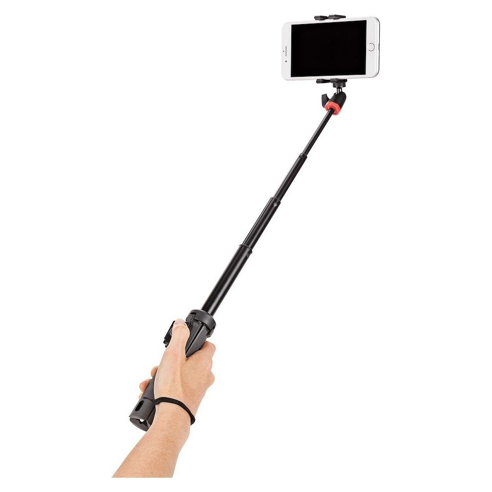 Una mano tiene un selfie stick nero con un telefono bianco all'estremità.