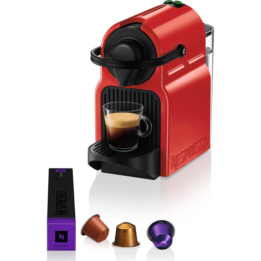 Macchina Nespresso rossa con tazzina da espresso e tre capsule.