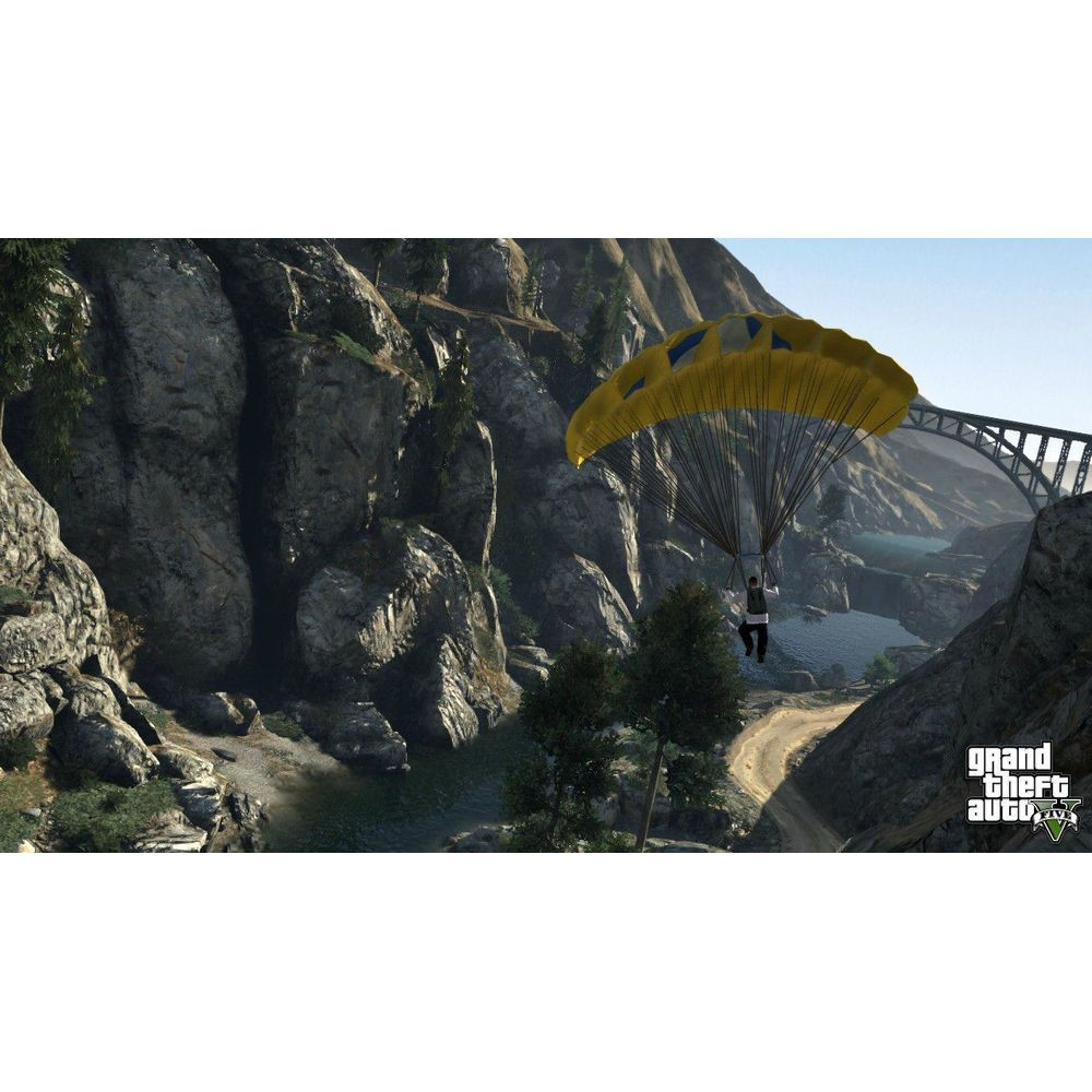 Ein Mann mit gelbem Fallschirm fliegt über eine Schlucht mit Fluss und Brücke.