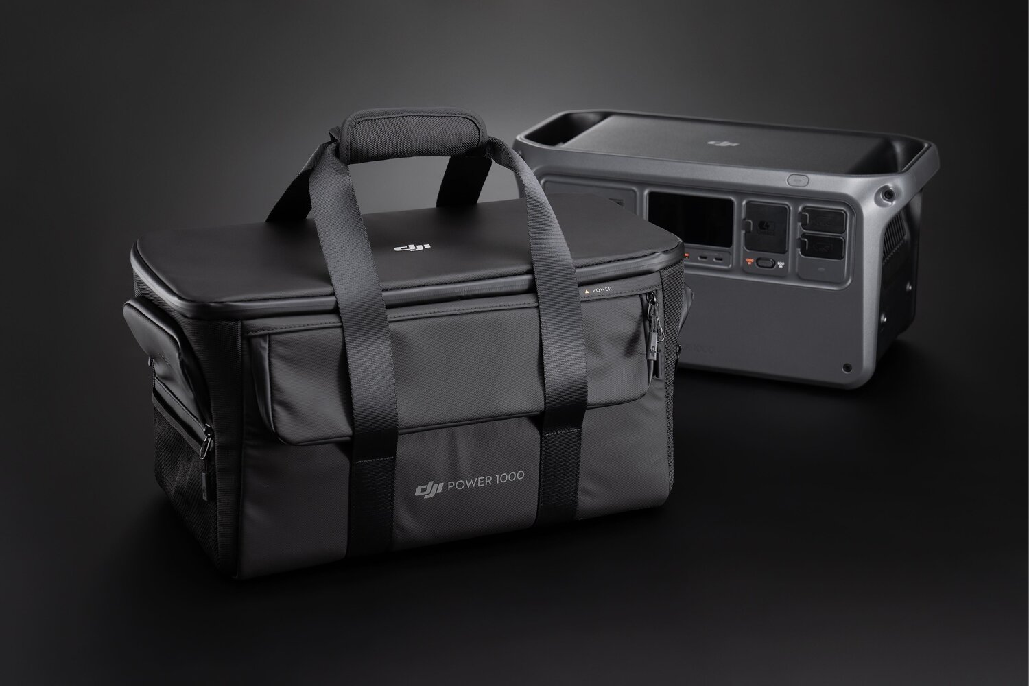 Eine schwarze DJI Power 1000 Tasche und eine graue Powerstation stehen auf dunkler Fläche.