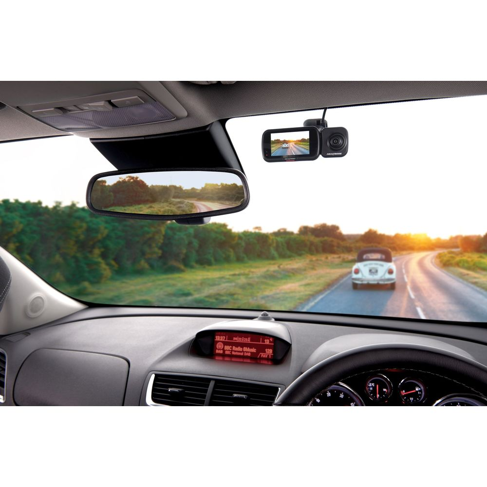 Vista interna dell'auto su strada con maggiolino bianco e dashcam. Tramonto.
