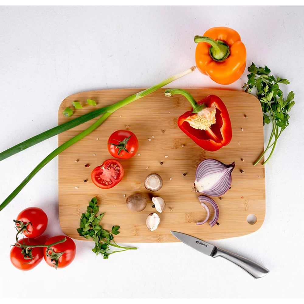 Verdure fresche tra cui pomodori, peperoni, cipolle e funghi su un tagliere.