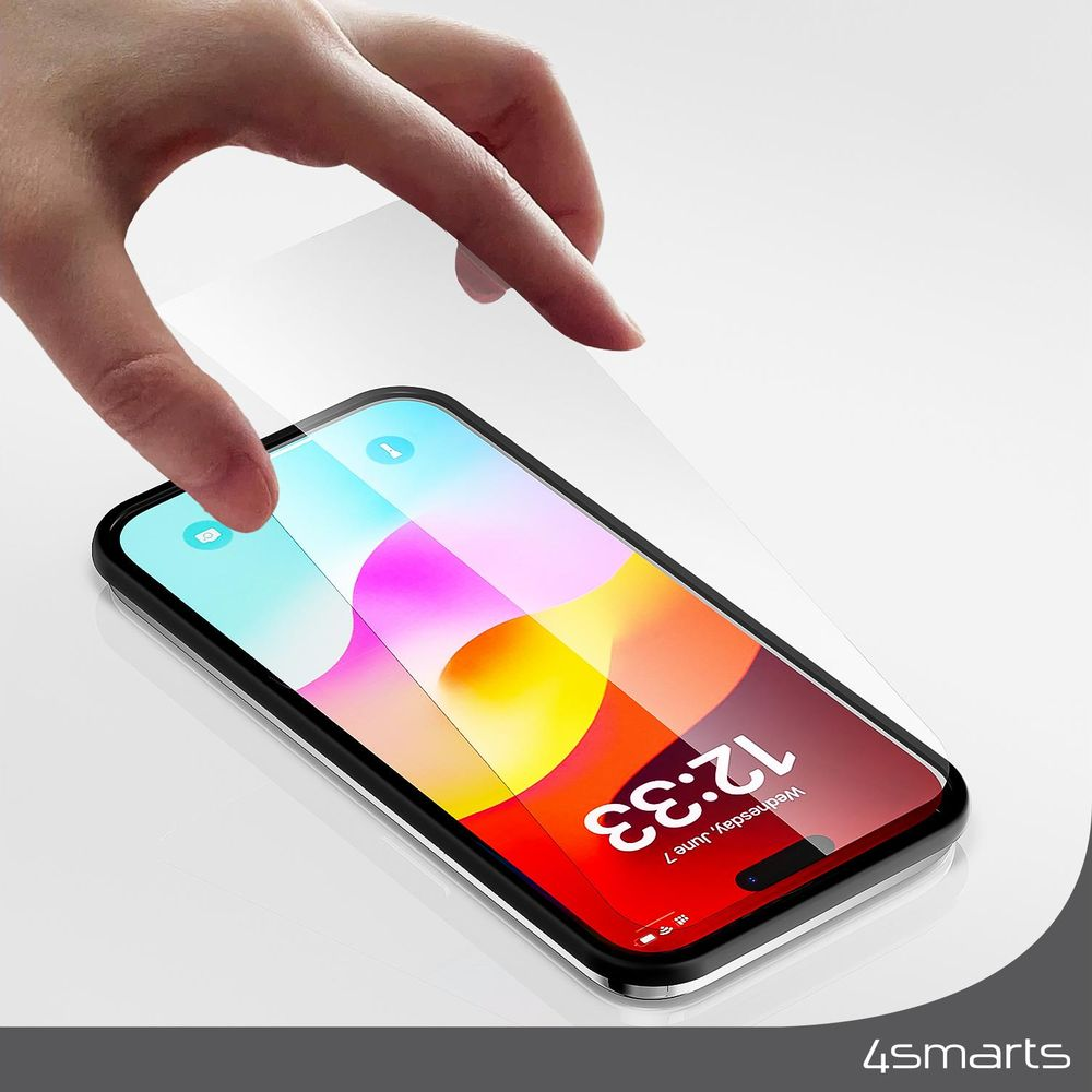 Una mano applica una protezione schermo su uno smartphone con uno sfondo colorato.