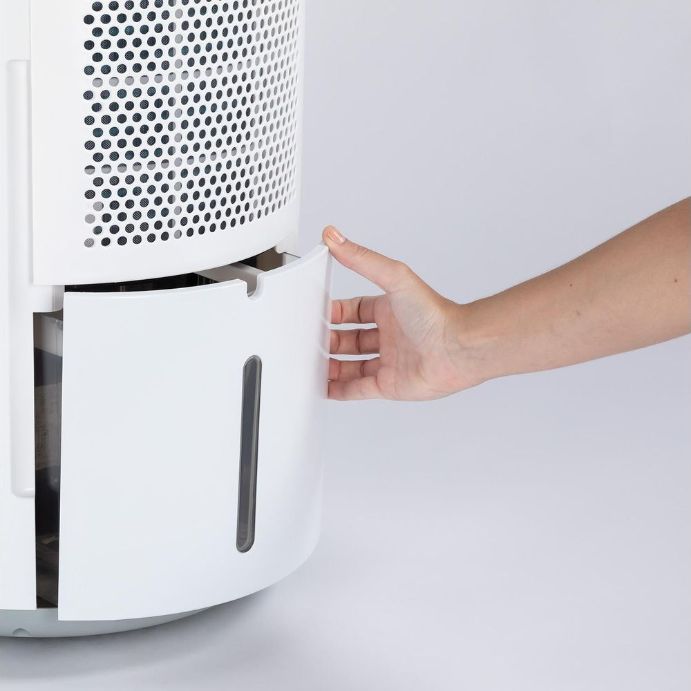 Mano che apre cassetto bianco di deumidificatore con finestra di ispezione.