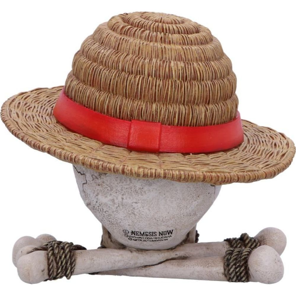 Una calavera con sombrero de paja y cinta roja, huesos cruzados.