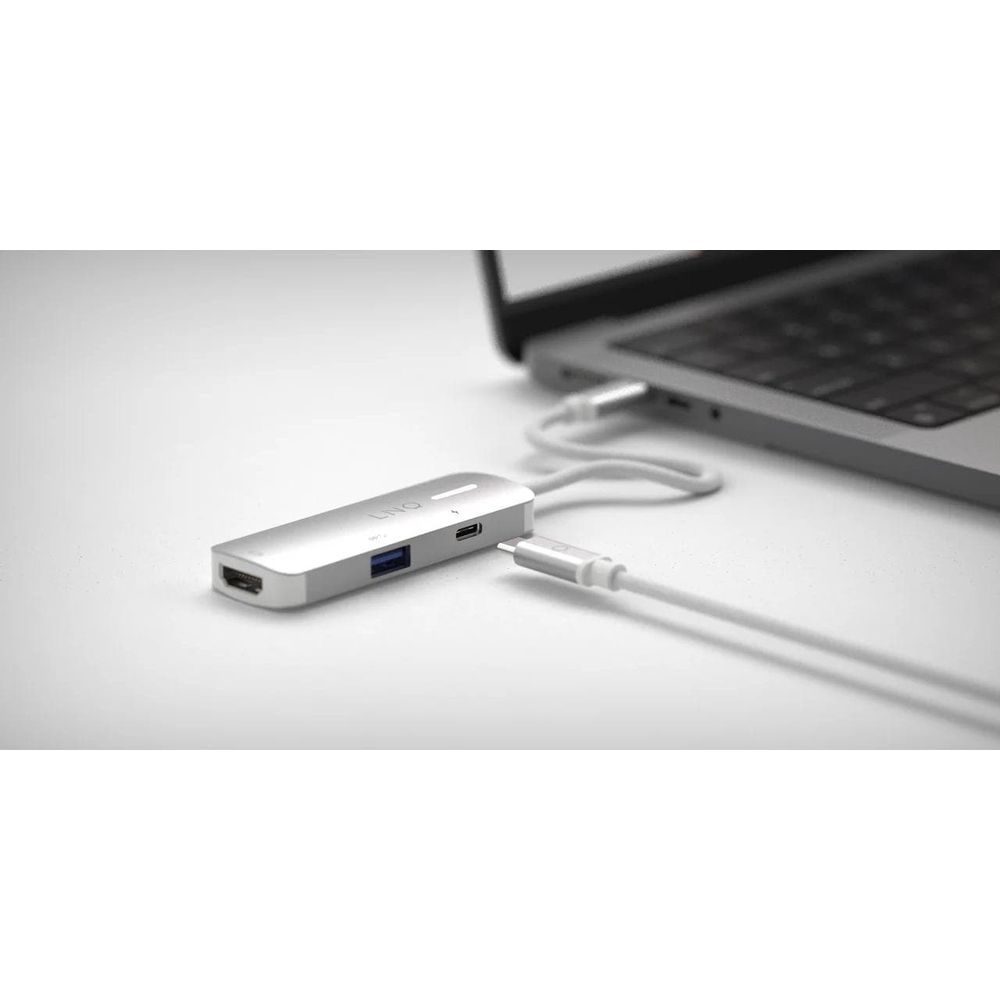 Un hub USB-C argentato con porte HDMI e USB è collegato a un laptop.